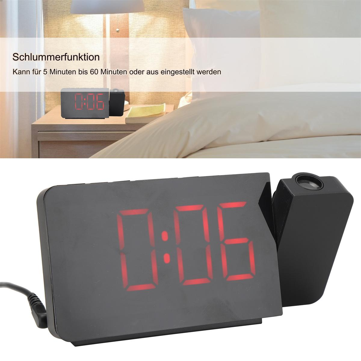 Digitaler Wecker mit Anzeige 0:06 und Projektionsfunktion. Er steht auf einem Bett.