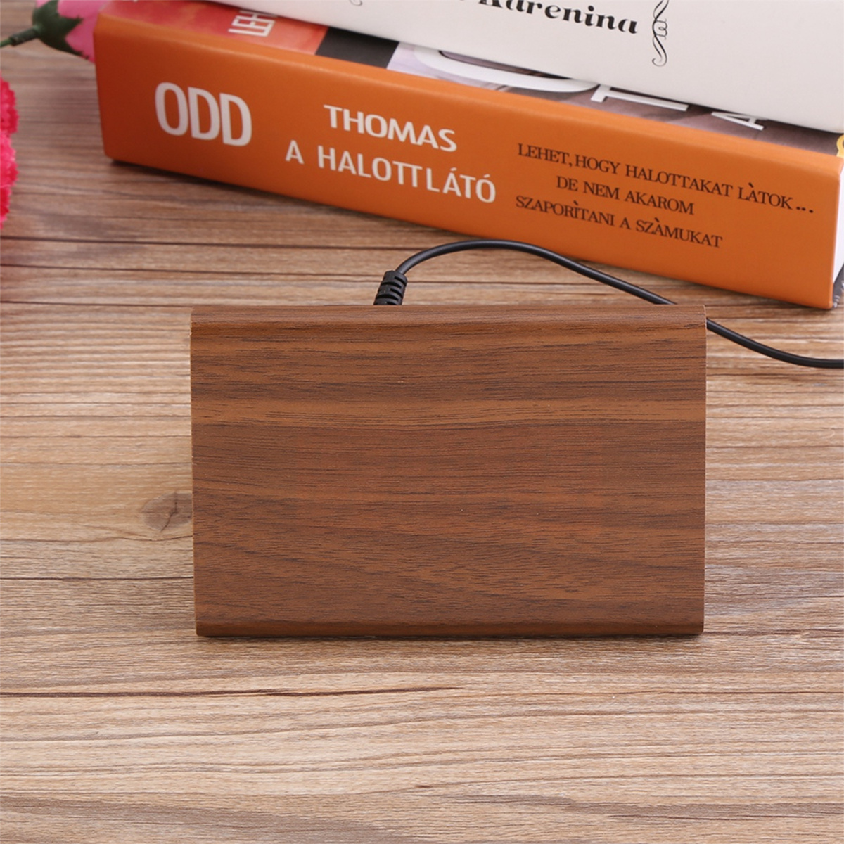 Holzblock mit Text auf einem Holztisch, mit Büchern im Hintergrund.
