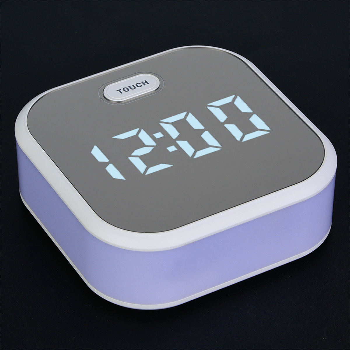 Quadratischer digitaler Wecker. Die Anzeige zeigt 12:00 Uhr. Es hat eine Touch-Taste.