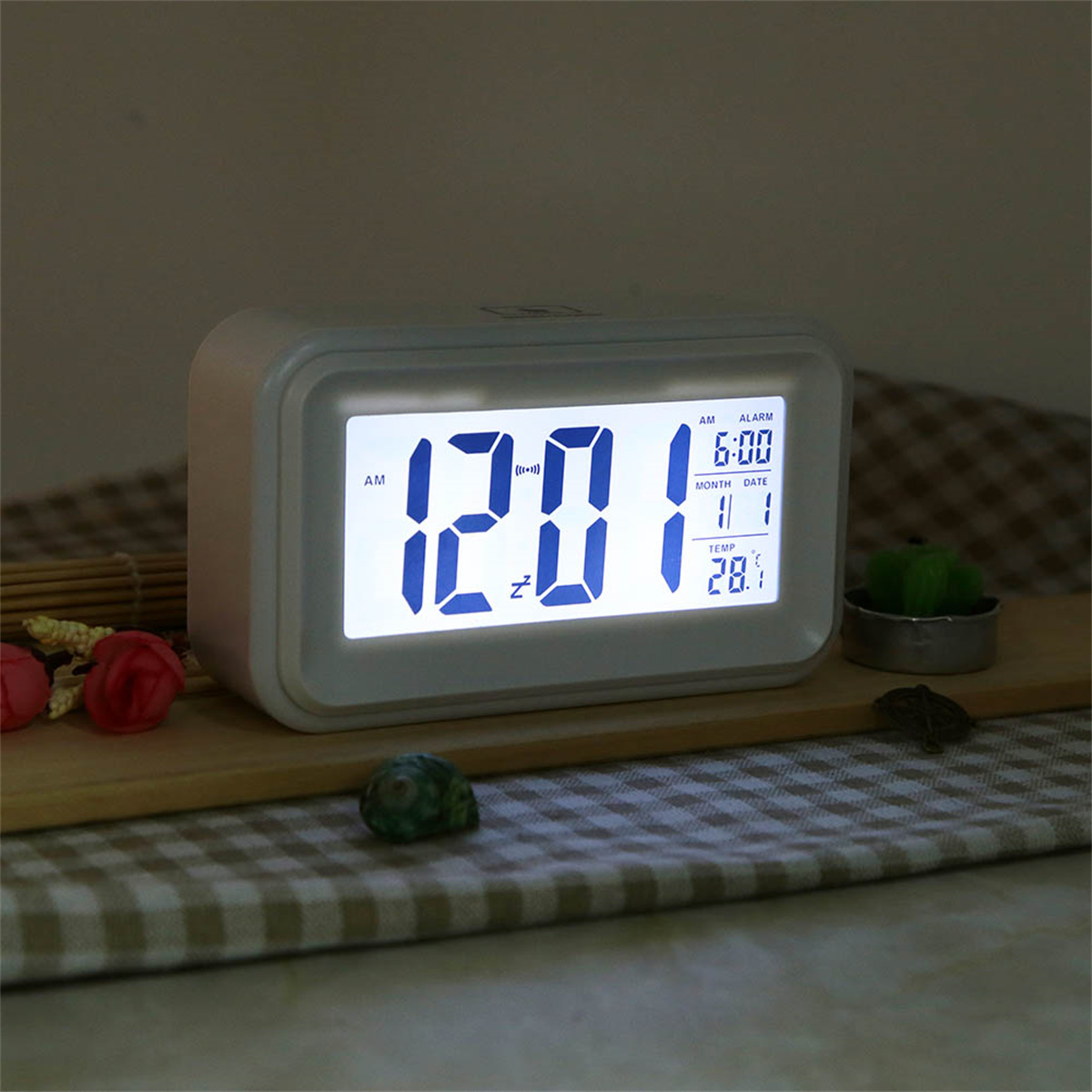 Weiße Digitaluhr, die Zeit und Datum anzeigt, auf Holzoberfläche.