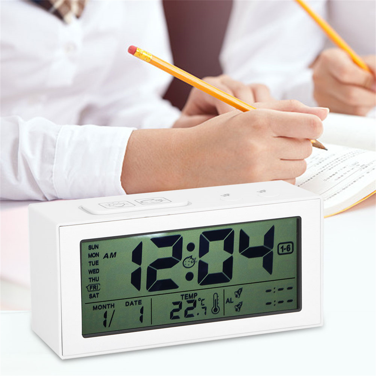 Eine weiße Digitaluhr mit der Uhrzeit 12:04, Datum und Temperatur, mit Personen im Hintergrund.