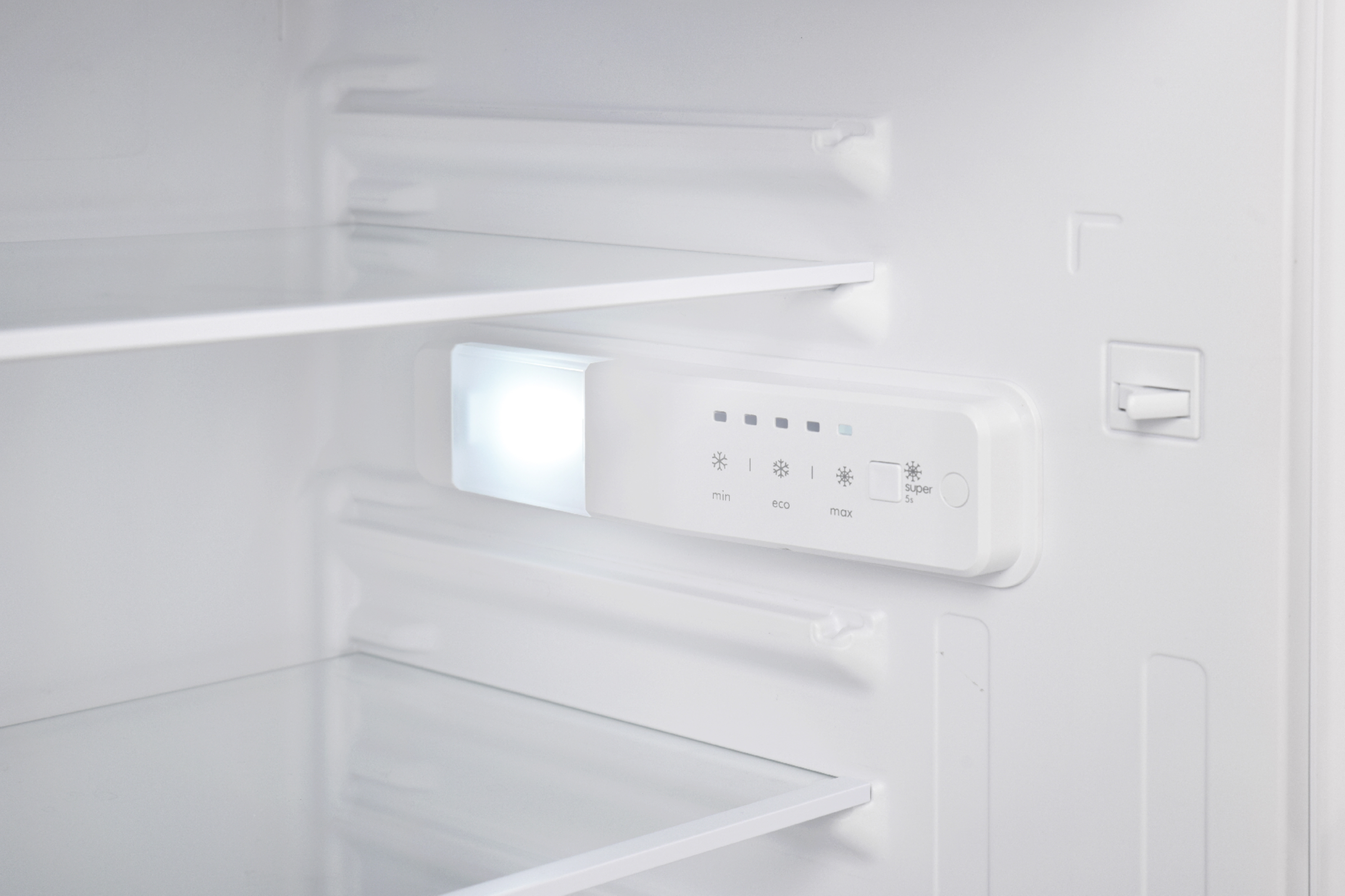 Inside of a white refrigerator. Shows shelves and control panel with lights.