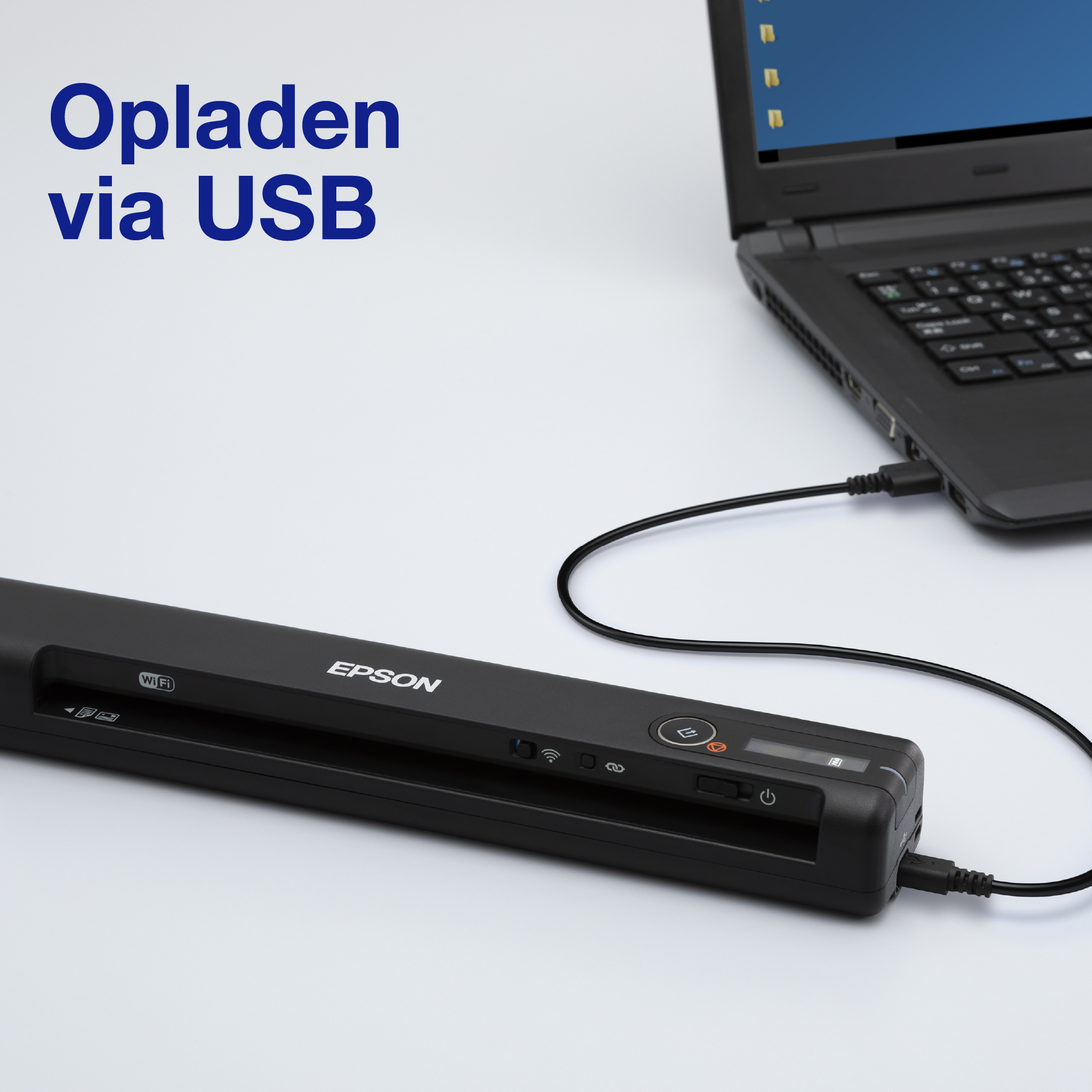 Czarny skaner Epson podłączony do laptopa. Na ekranie napis 'Opladen via USB'.