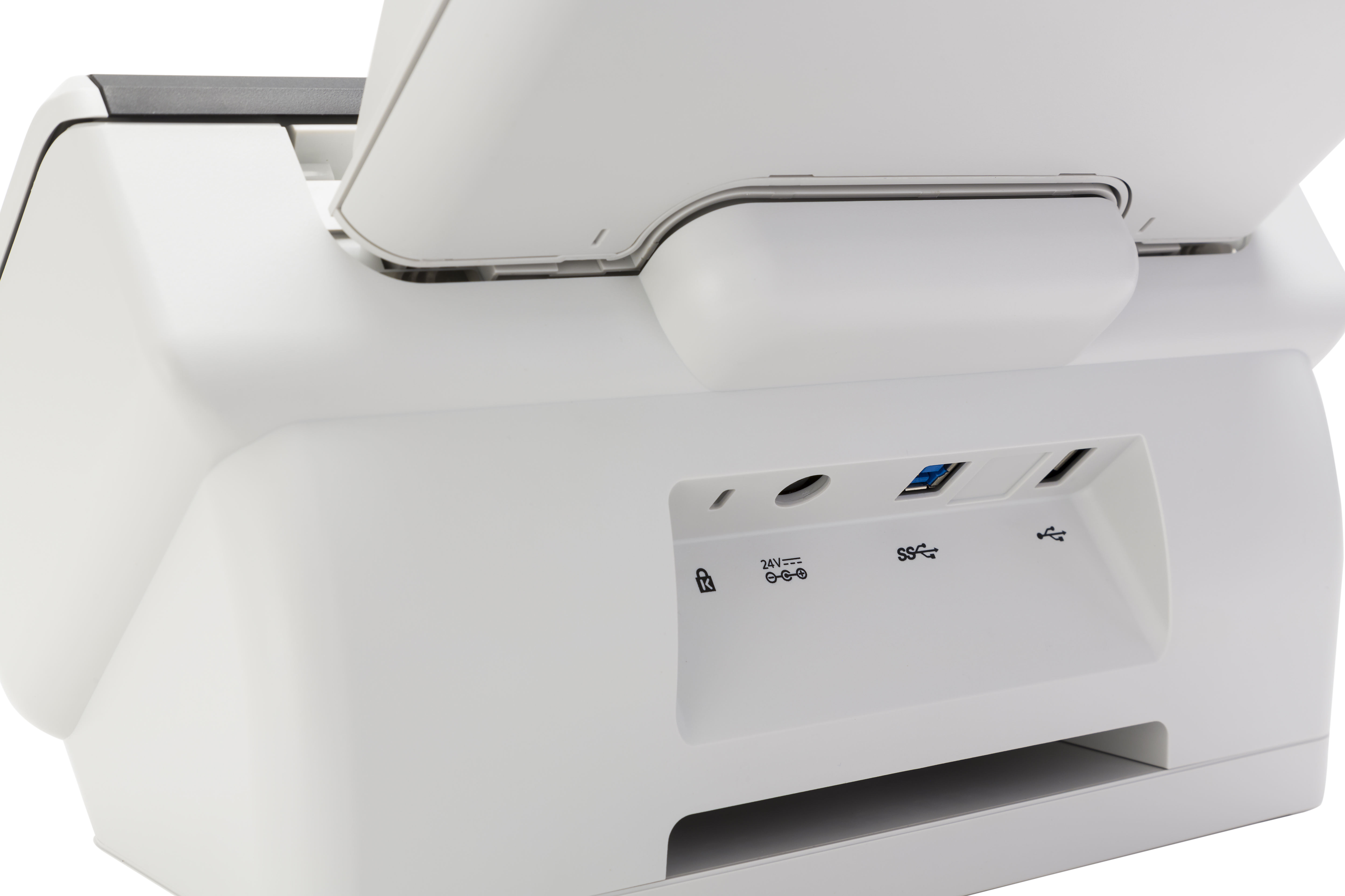 Zbliżenie tyłu skanera z portami i etykietami. Biała plastikowa obudowa.