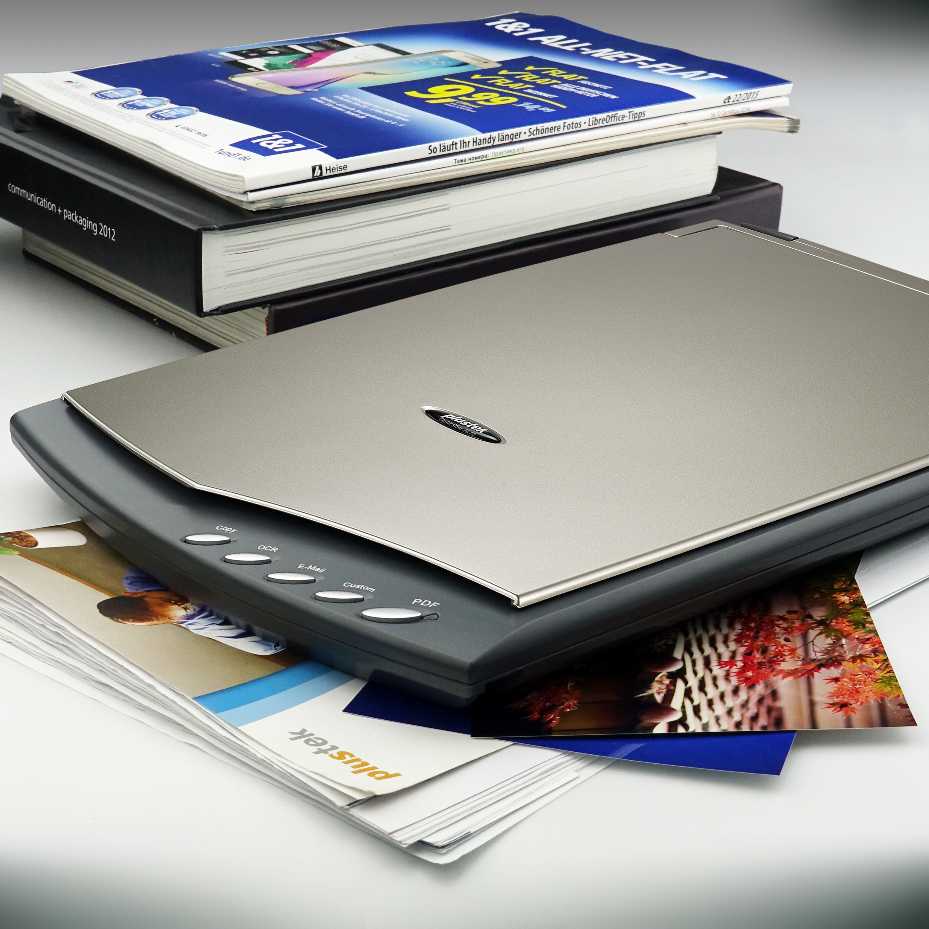 Scanner con libri e documenti. Uno scanner grigio con carta sopra.