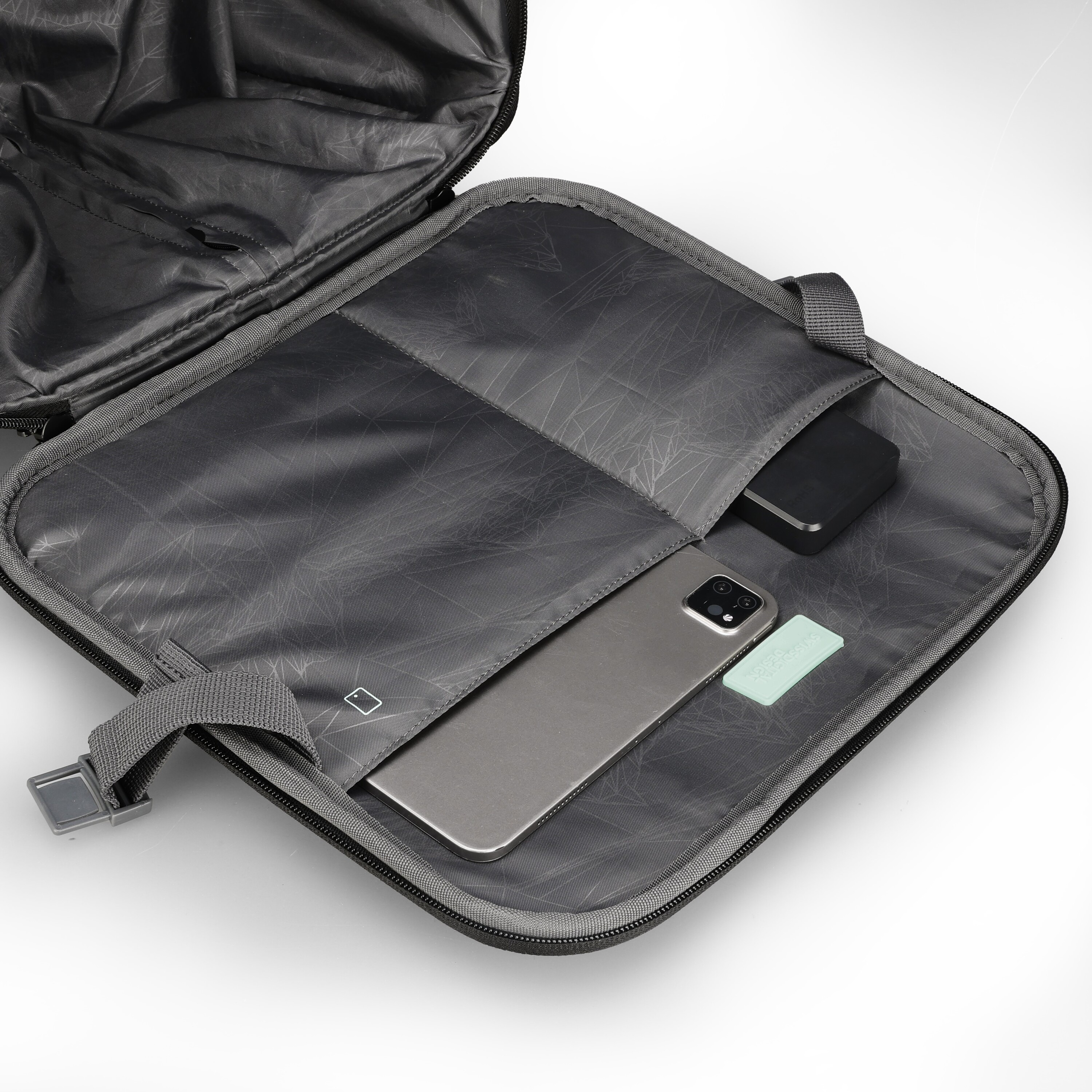 Borsa per laptop grigia, aperta. Contiene un telefono e altri oggetti. Lo sfondo è bianco.