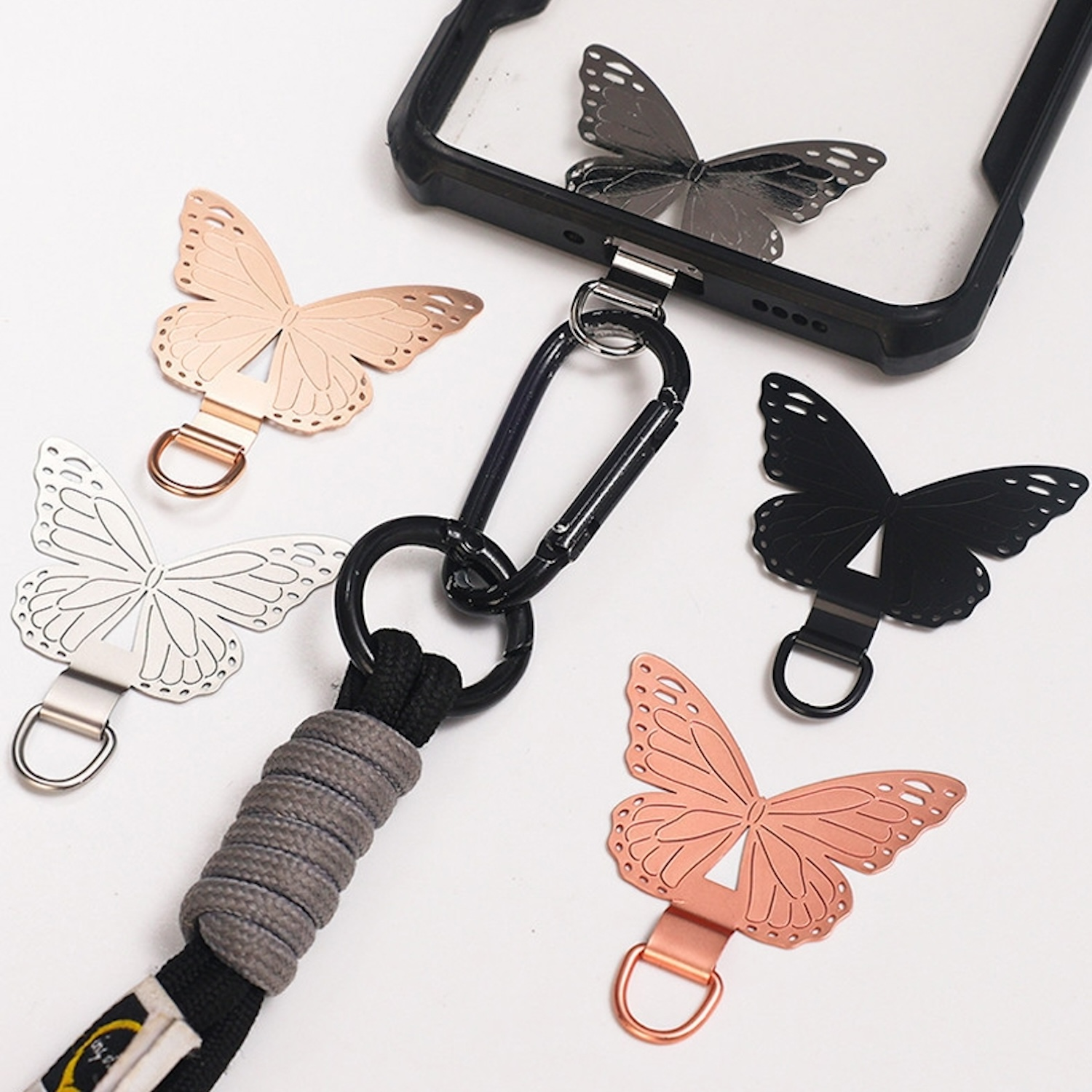 Handyhülle mit Schmetterlingen, schwarzem Schlüsselband und verschiedenen Schmetterlingsdesigns.