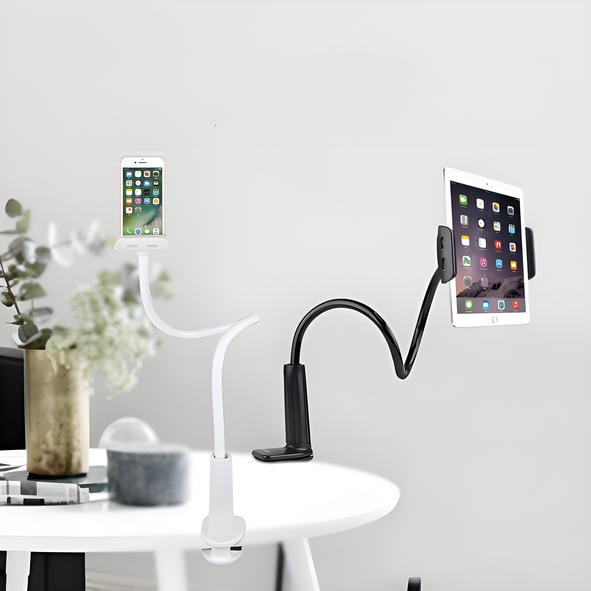 Zwei Handy- und Tablethalter auf einem weißen Tisch, mit weißer Wand im Hintergrund.