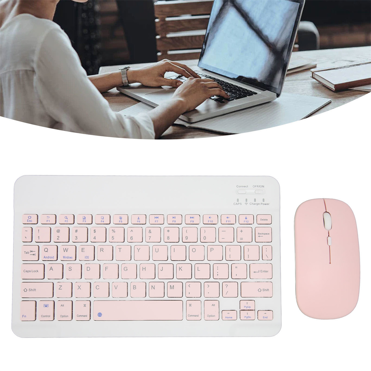 Person benutzt Laptop, pinkes Tastatur-Maus-Set auf dem Tisch.
