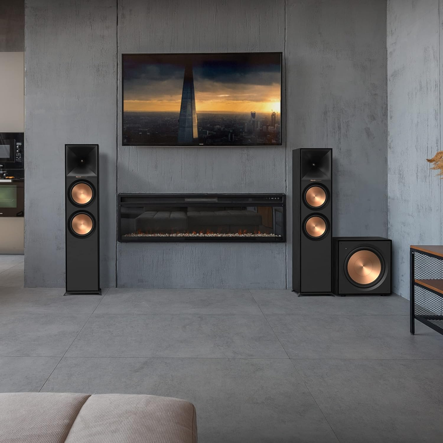 Wohnzimmer mit Fernseher, Lautsprechern, Kamin und beigem Sofa, modernes Design.