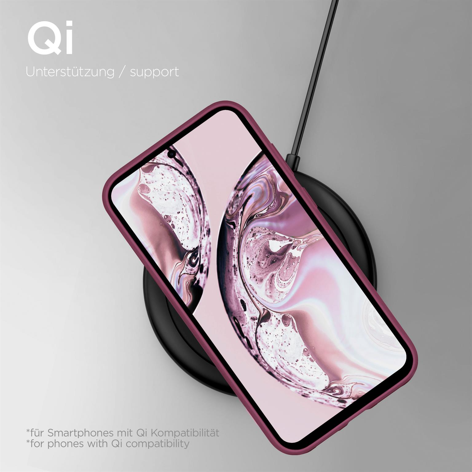 Ein Telefon in einer rosa Hülle auf einem kabellosen Ladegerät. Der Hintergrund ist hellgrau.