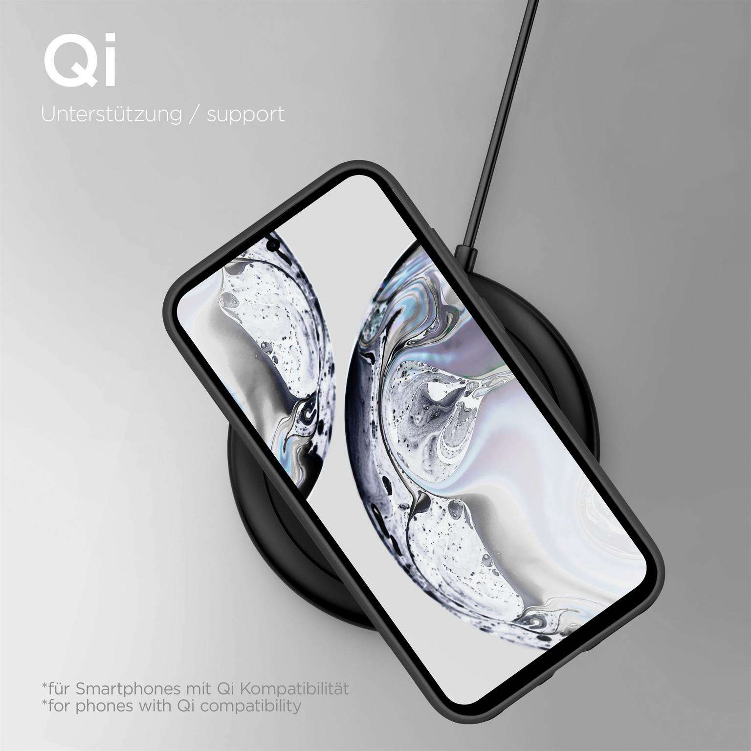 Schwarzes Telefon auf einem kabellosen Ladegerät mit Text, der Qi-Kompatibilität anzeigt.