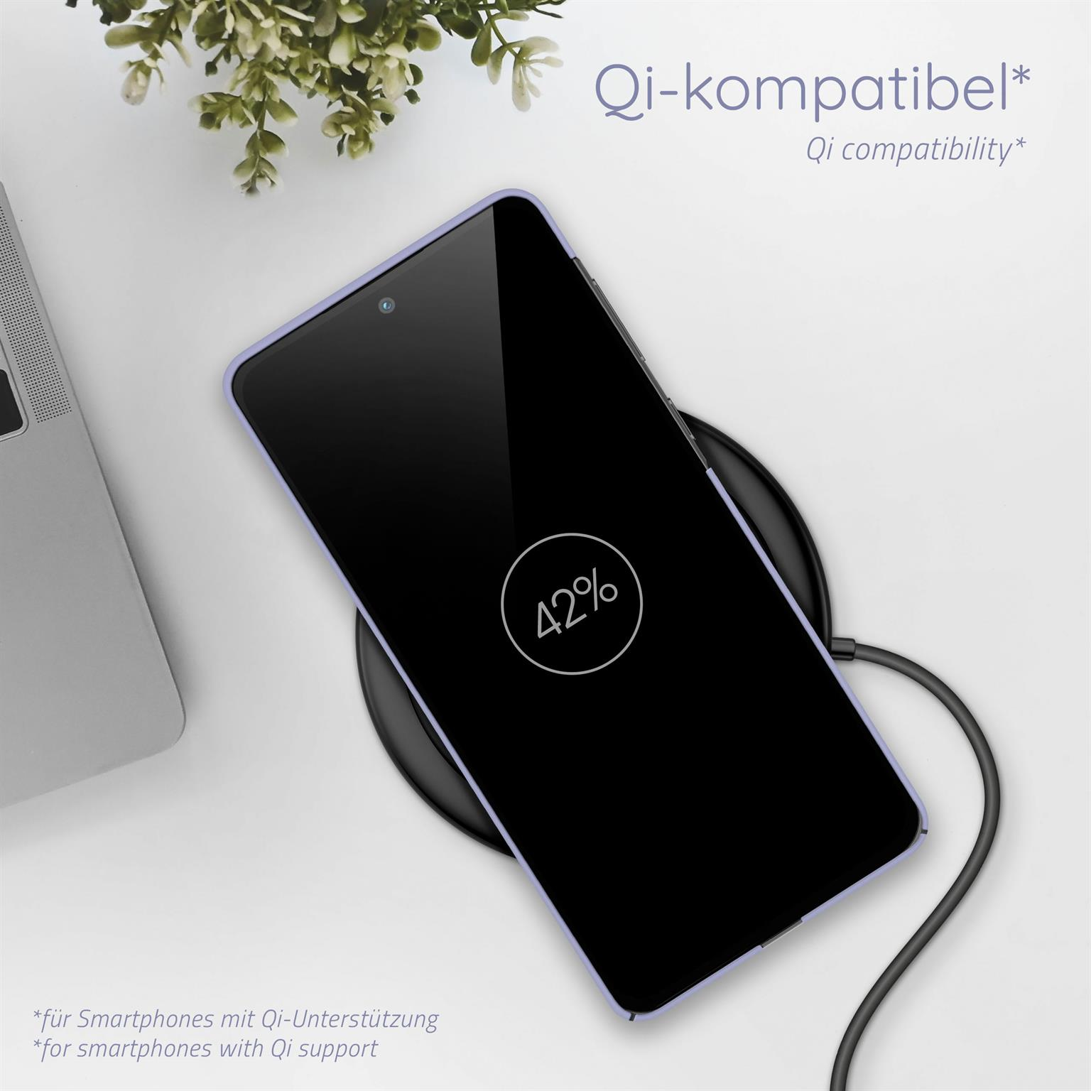 Ein Smartphone, das auf einem kabellosen Ladegerät lädt und 42 % anzeigt. Eine Pflanze und ein Laptop im Hintergrund.