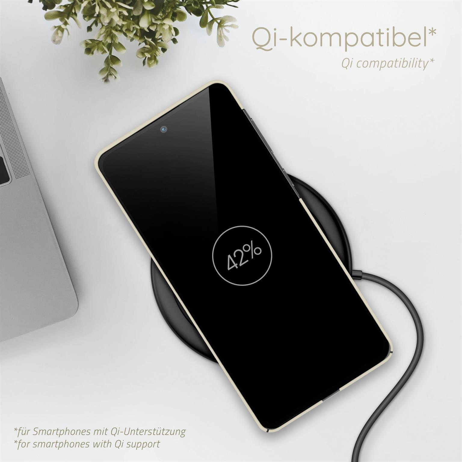 Telefon lädt kabellos auf. Es zeigt 42% Ladung an. Blätter und Laptop im Hintergrund.