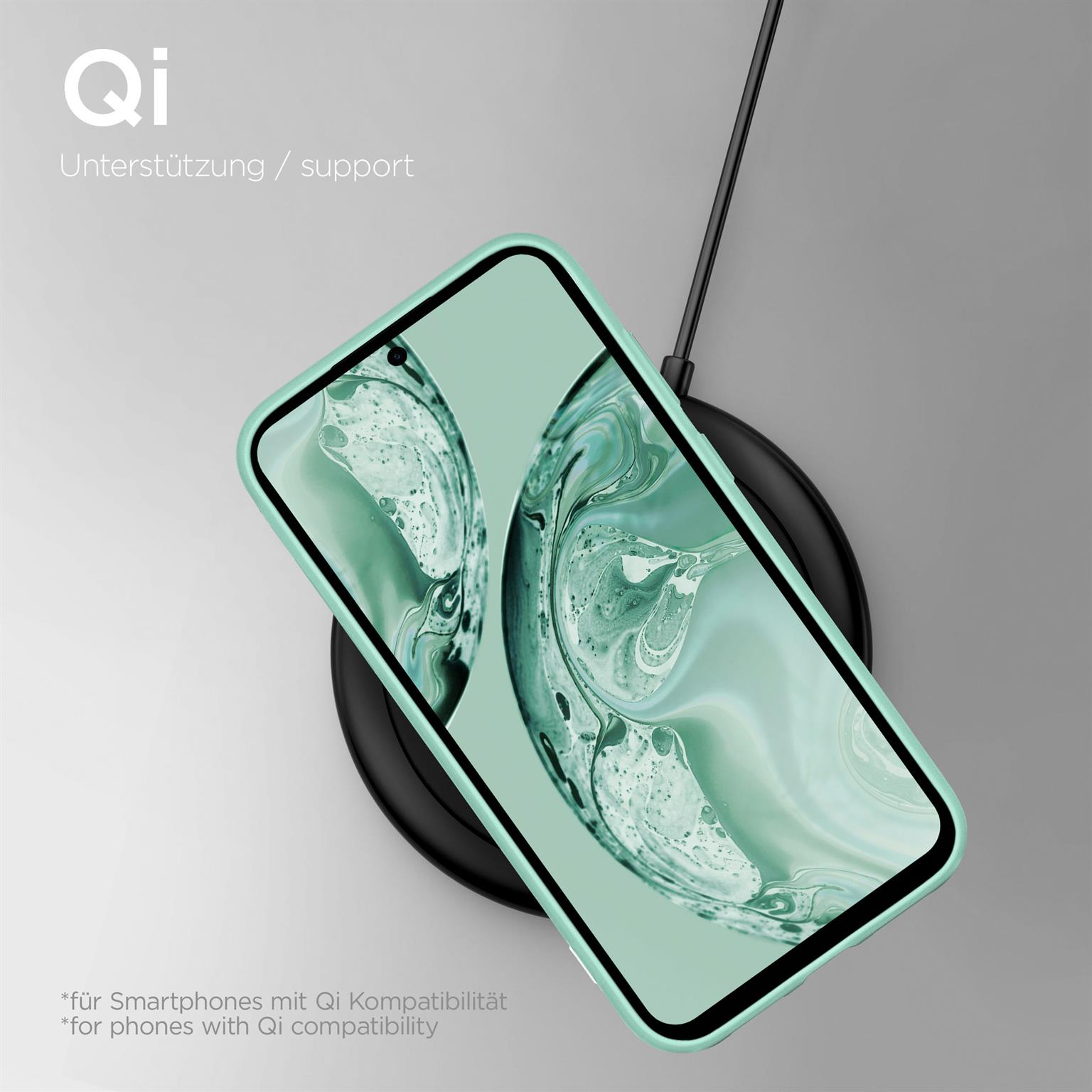 Ein Telefon in einer hellgrünen Hülle auf einem schwarzen kabellosen Ladepad mit Kabel.