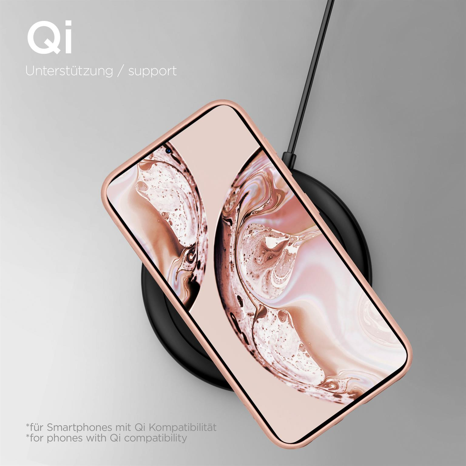 Telefon auf schwarzem kabellosen Ladegerät, in roségoldener Hülle. Grauer Hintergrund.