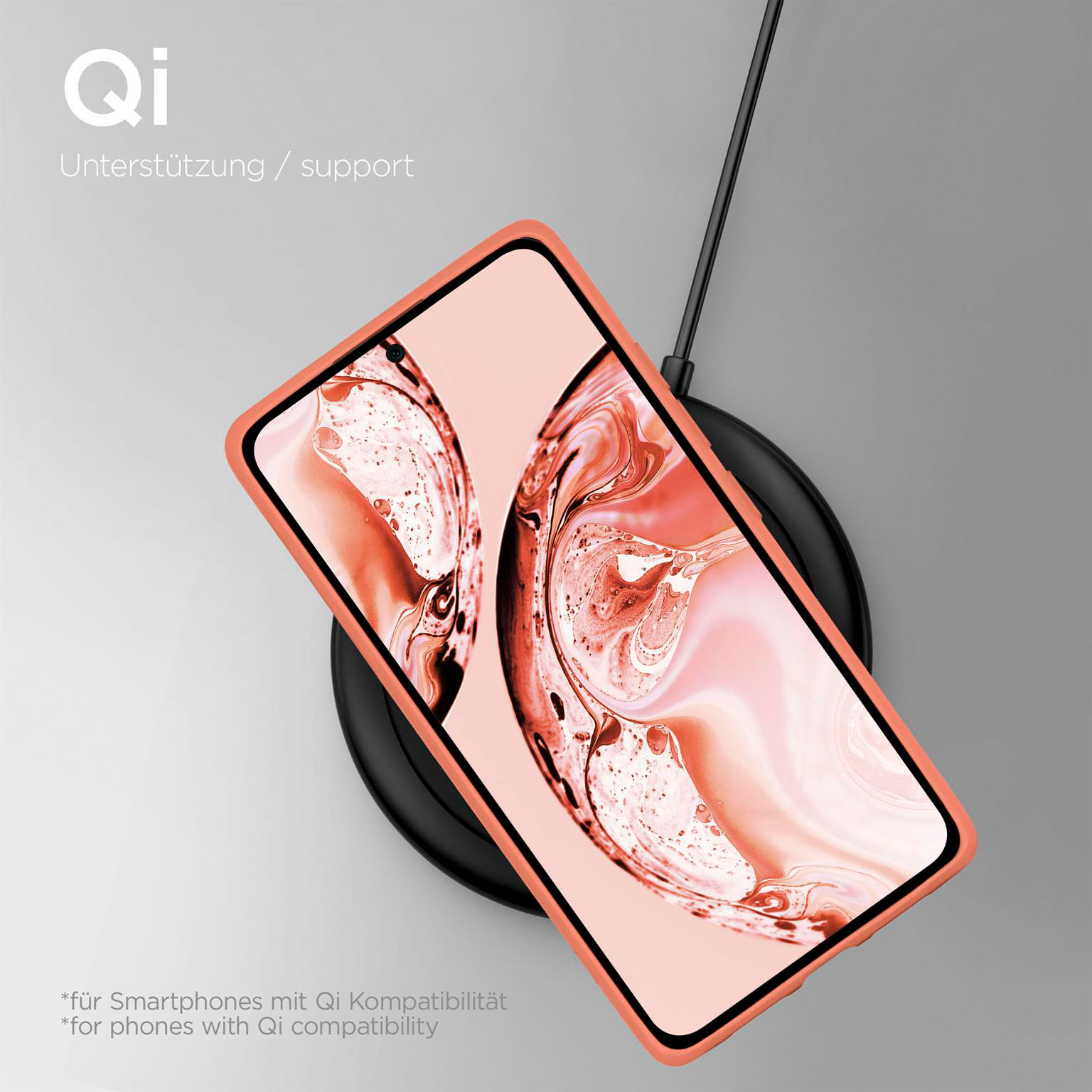 Korallenfarbenes Telefon in einer Hülle, kabelloses Laden auf schwarzer Scheibe. QI-Unterstützung.