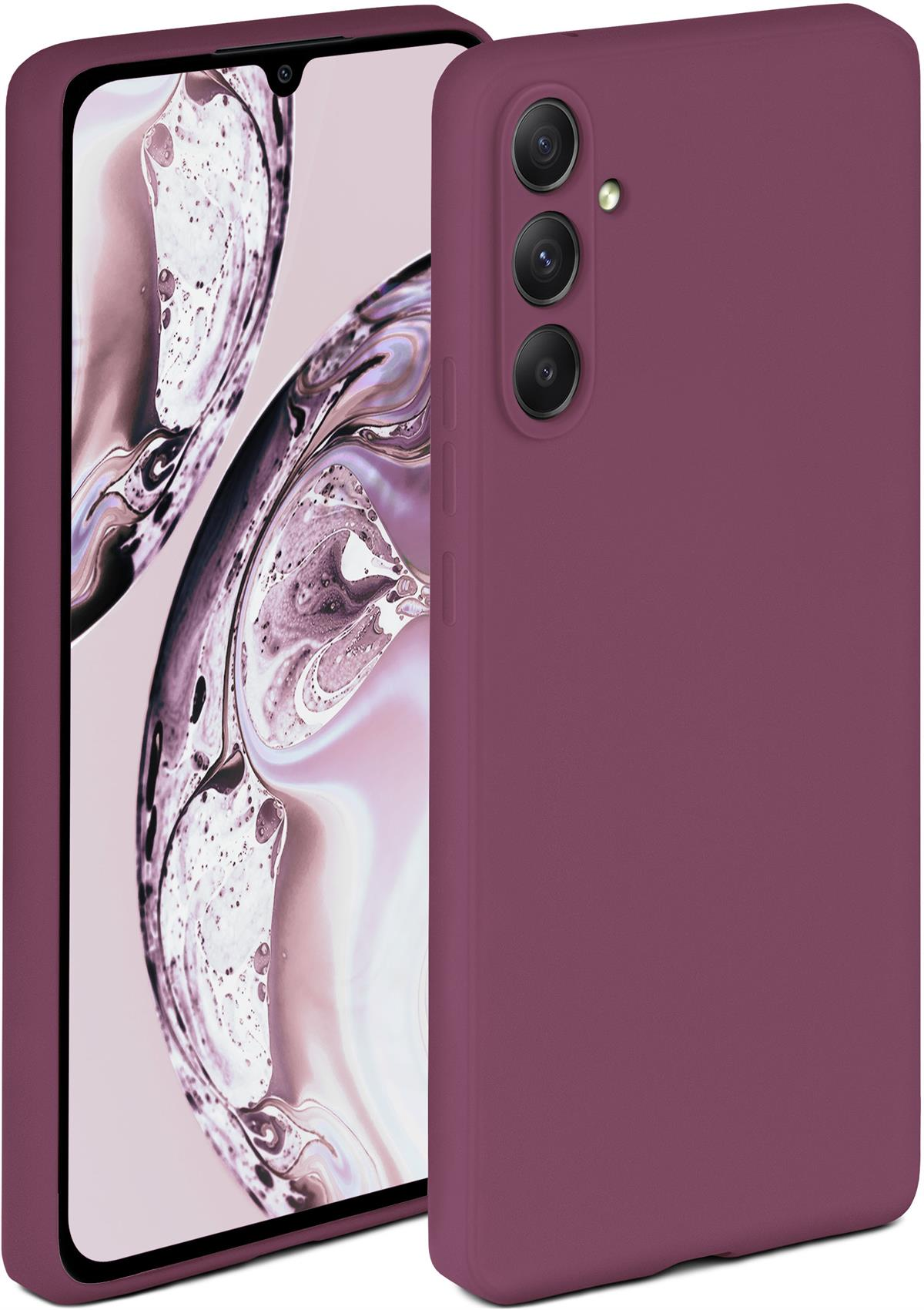Bordeauxrote Handyhülle auf einem Smartphone. Hülle teilweise geöffnet, Telefon sichtbar. Lila Hintergrund.