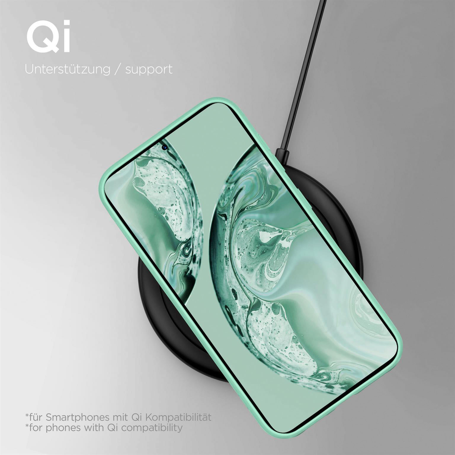 Ein grünes Telefon in einer Hülle auf einem schwarzen Qi-Ladepad. Der Bildschirm zeigt einen grünen Hintergrund.