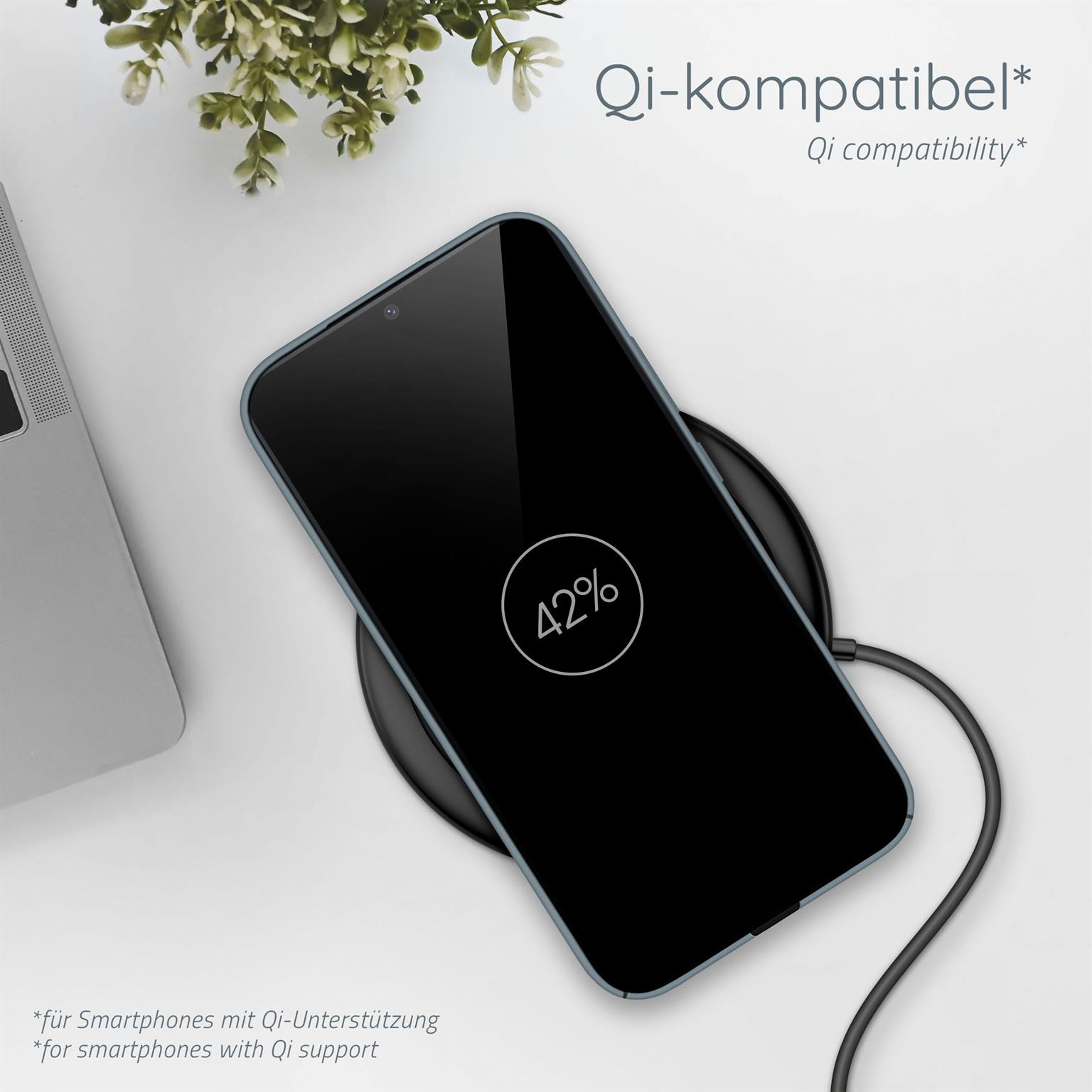 Ein Telefon mit blauem Gehäuse auf einem kabellosen Ladegerät, mit 42 % auf dem Bildschirm. Eine Pflanze im Hintergrund.