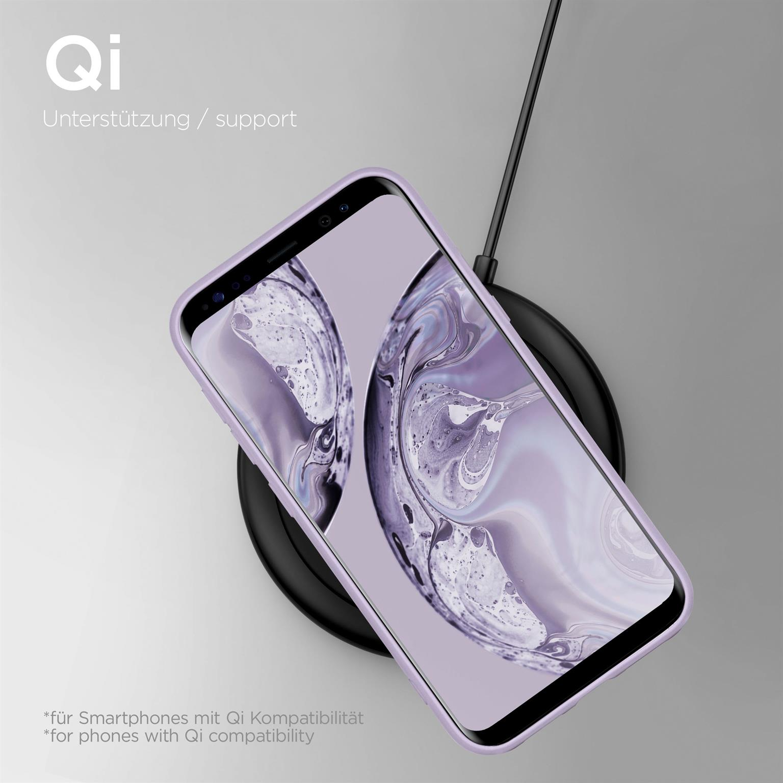 Telefon in lila Hülle, auf kabellosem Ladegerät. Text über Qi-Kompatibilität.