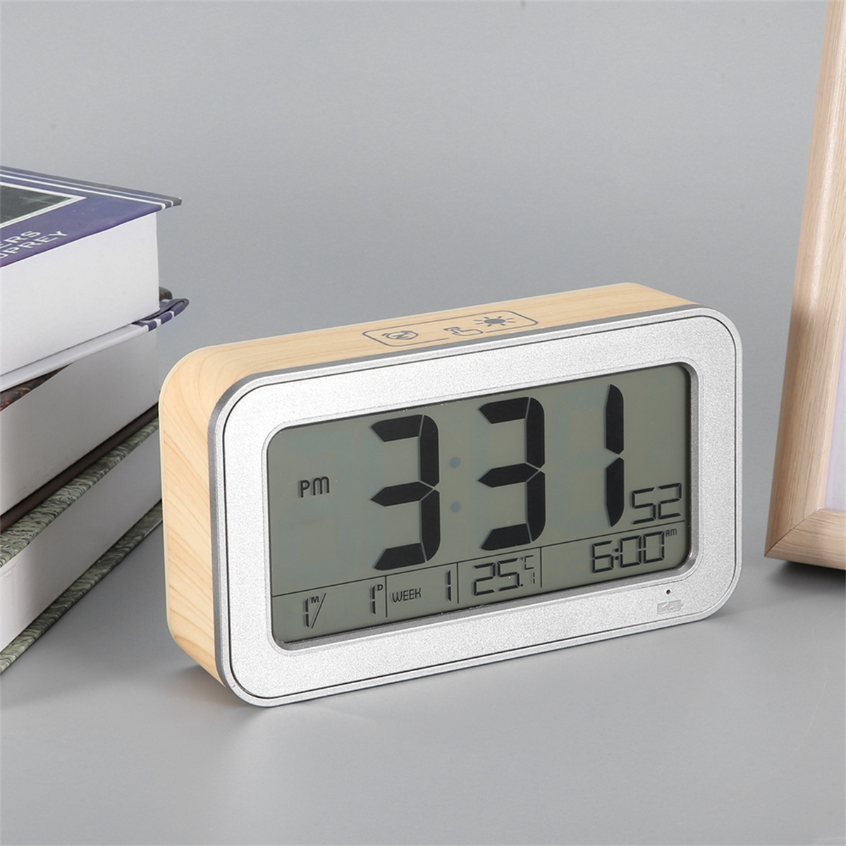 Eine digitaluhr mit Holzrahmen, die die Uhrzeit 3:31 und andere Informationen auf einer grauen Oberfläche anzeigt.
