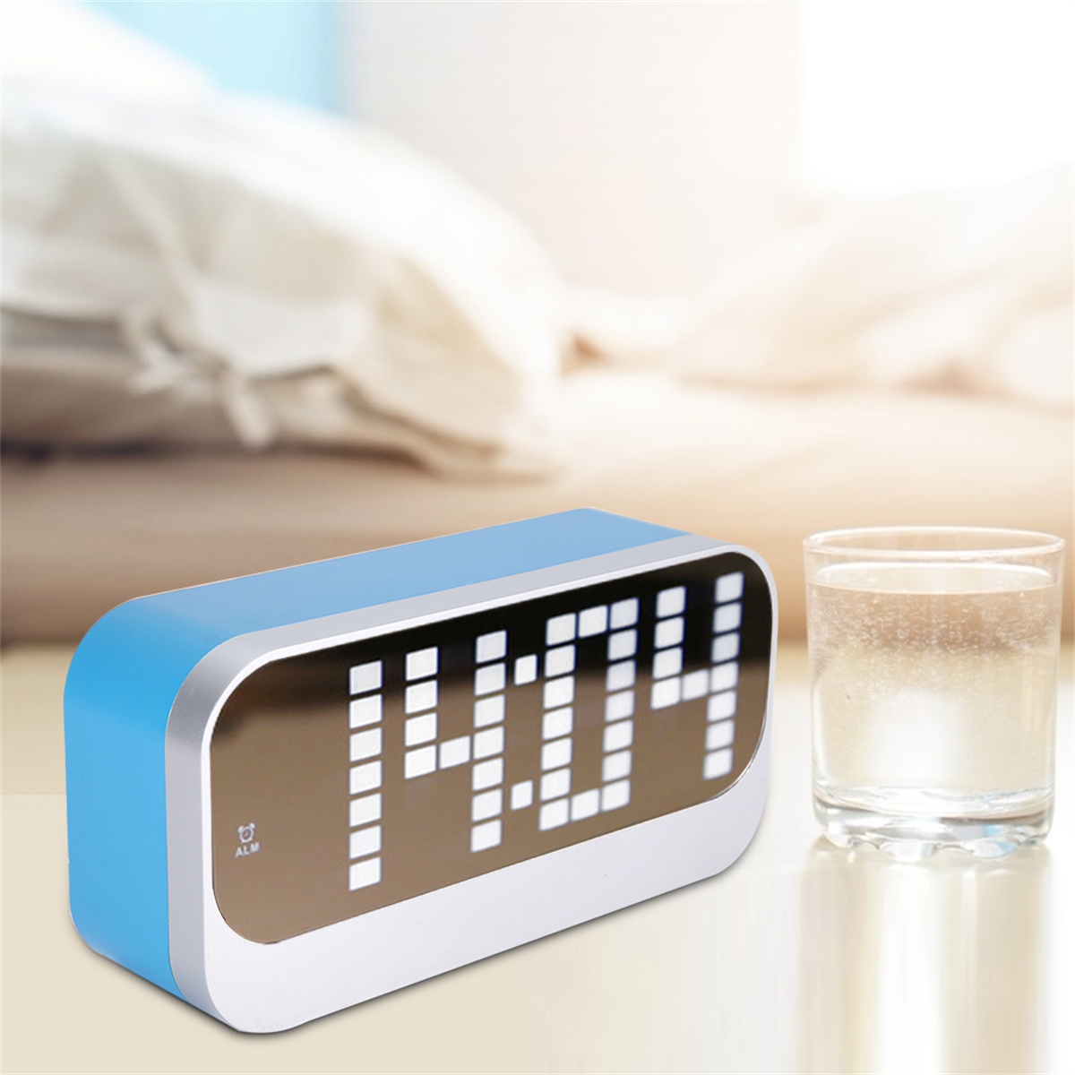 Ein blauer digitaler Wecker mit 14:04 steht auf einem Tisch mit einem Glas Wasser.