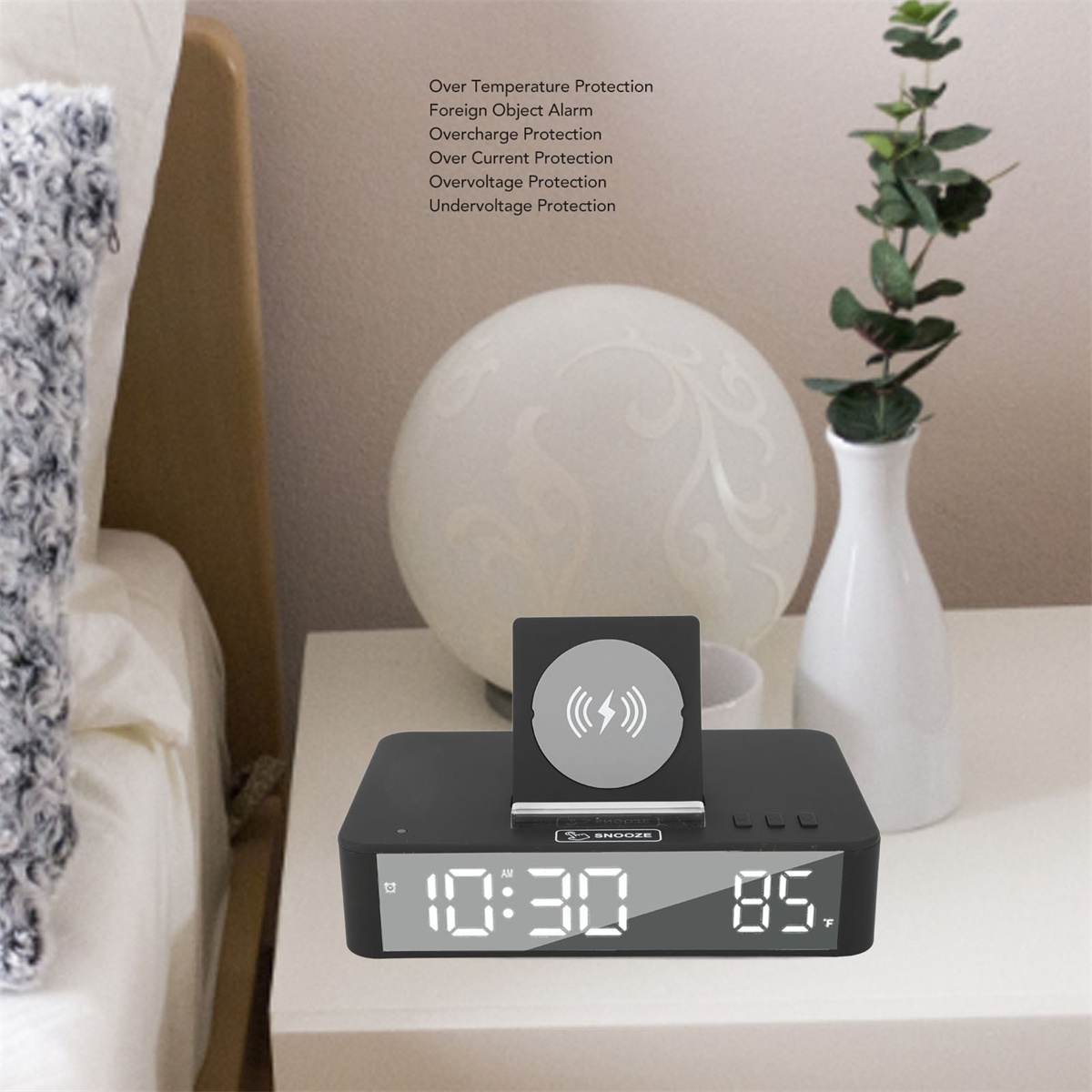 Digitaler Wecker auf einem Nachttisch, zeigt 10:30 und 85°F. Lampe und Pflanze im Hintergrund.