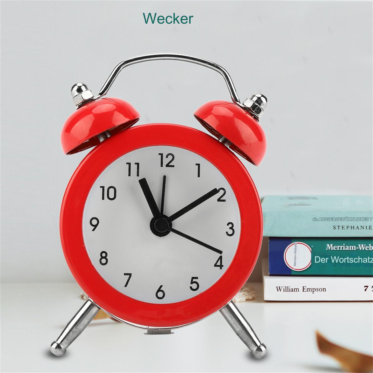 Roter Wecker auf weißer Oberfläche. Bücher sind im Hintergrund.