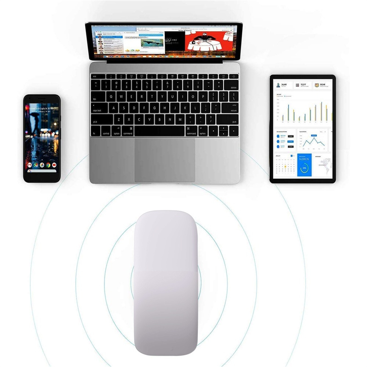 Ein Laptop, Telefon, Tablet und Maus sind auf einer weißen Oberfläche angeordnet.