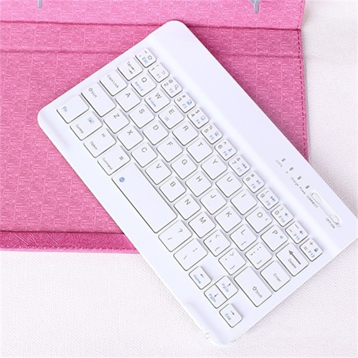 Weiße Tastatur auf pinkfarbener Tablet-Hülle. Weißer Hintergrund. Tasten sichtbar.