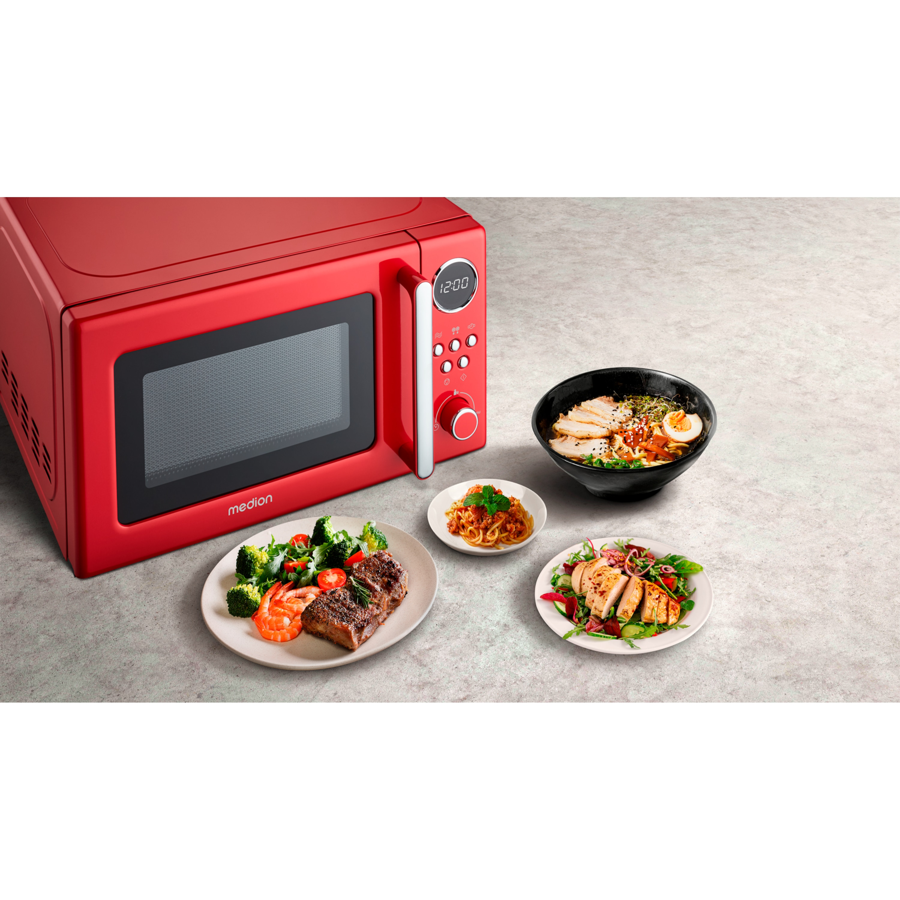 Czerwona kuchenka mikrofalowa z jedzeniem na talerzach. Jedzenie obejmuje stek, sałatkę i ramen. Białe tło.