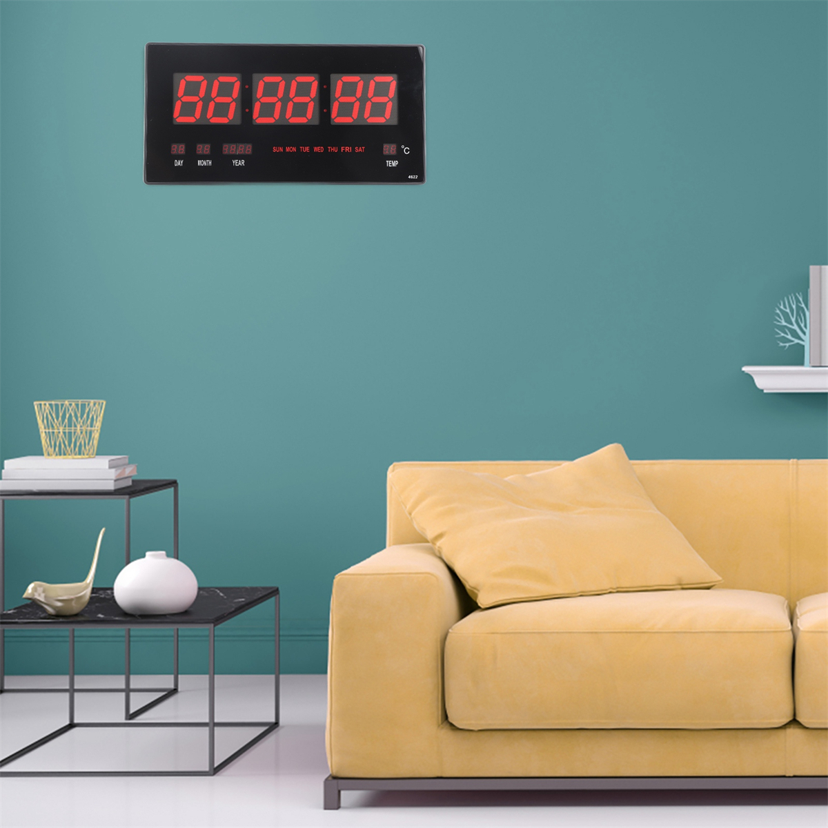 Digitaluhr mit roten Ziffern, die Zeit und Datum anzeigt. Sie ist an einer teal Wand angebracht.