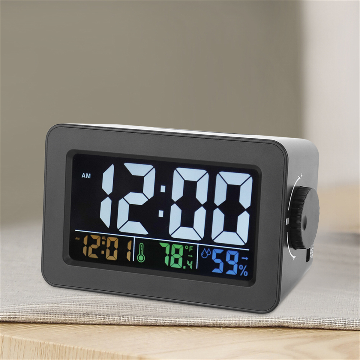 Digitaluhr mit Anzeige 12:00 AM, mit Temperatur, Luftfeuchtigkeit und einem Einstellrad.