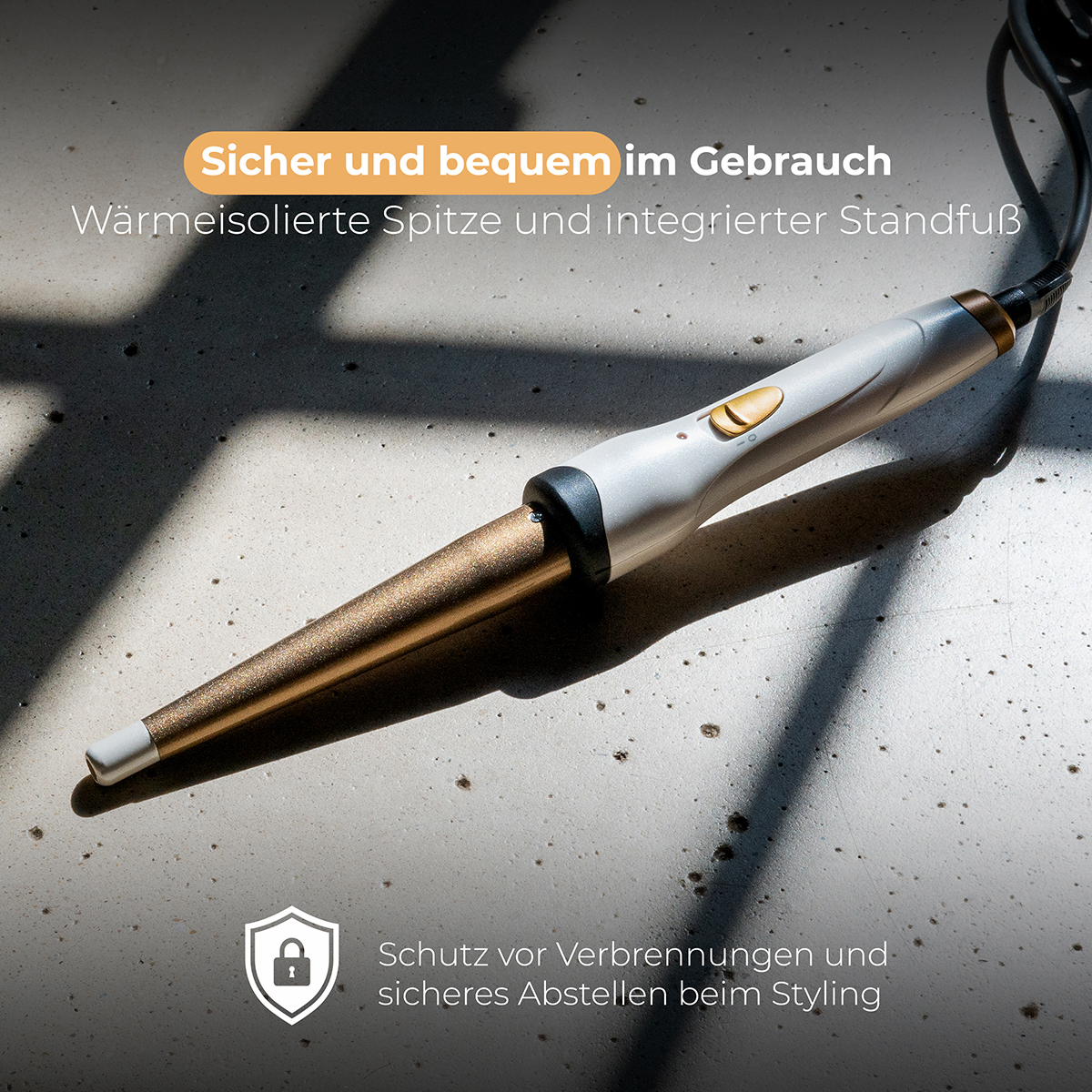 Lokówka ze złotą lufą i białym uchwytem, na teksturowanej powierzchni.