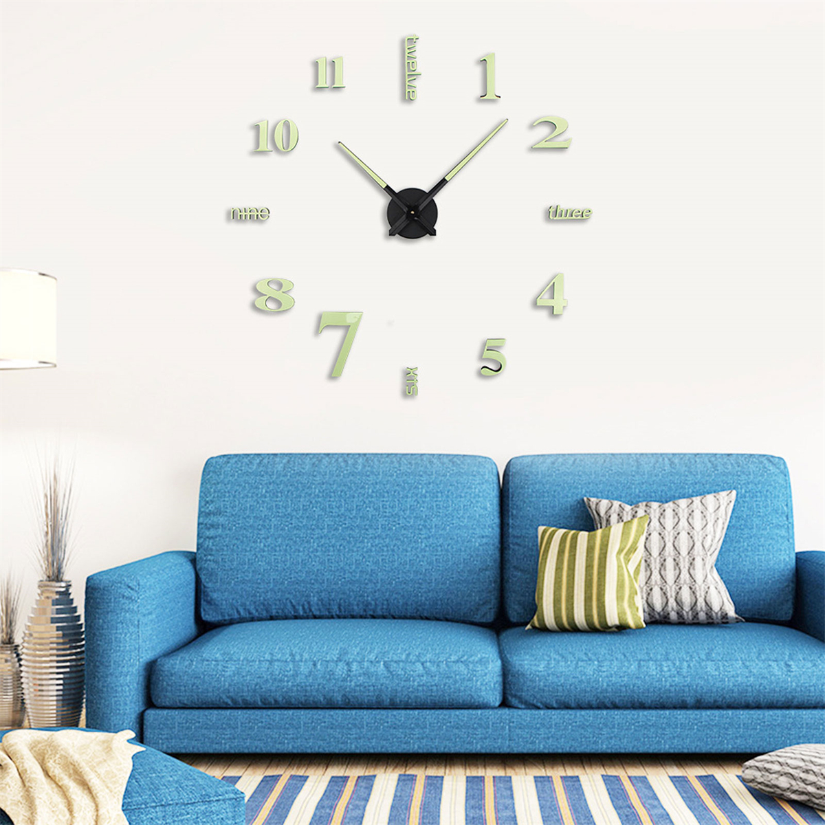 Wanduhr mit großen, leuchtenden Zahlen. Blaues Sofa im Hintergrund.