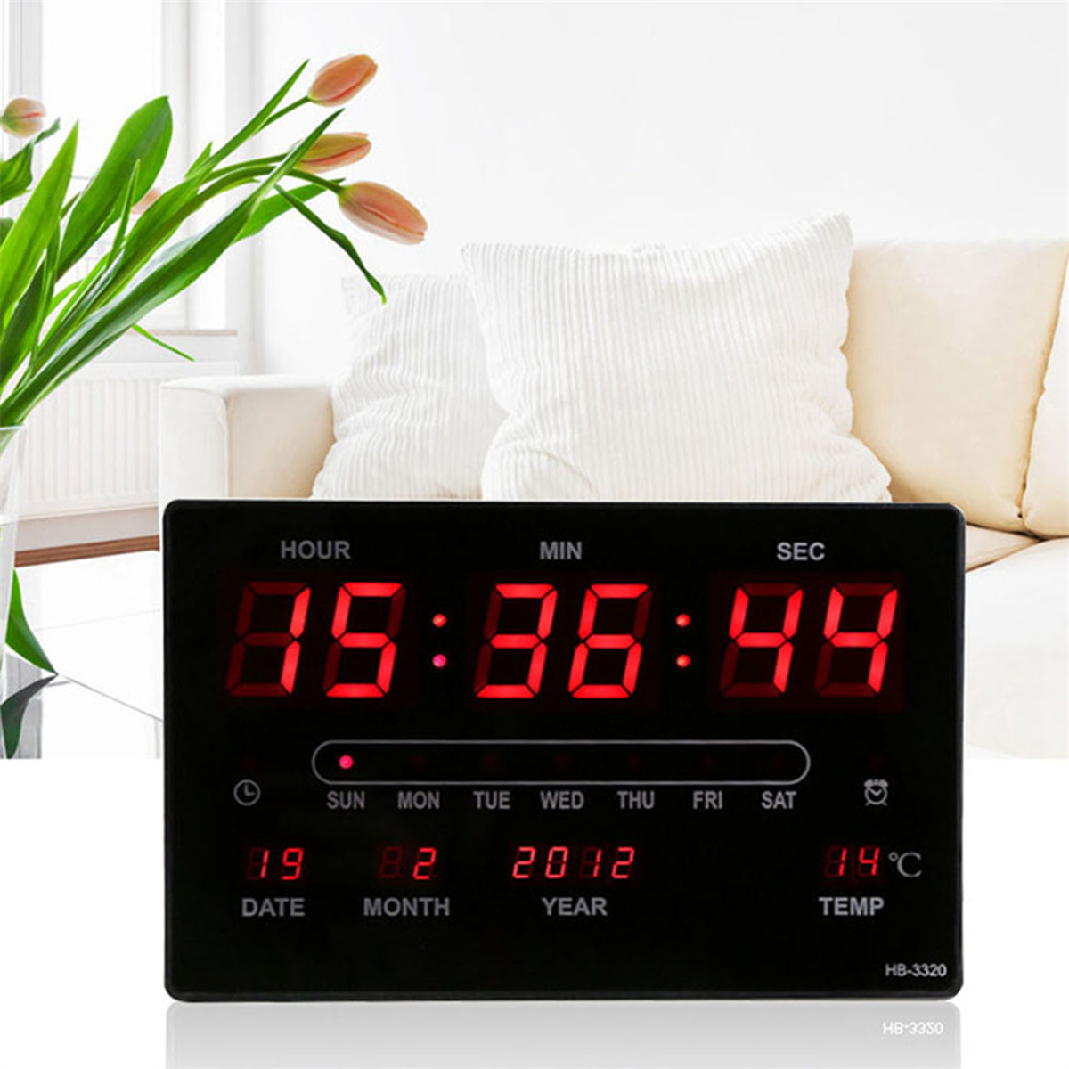 Eine Digitaluhr, die Zeit, Datum und Temperatur anzeigt. Hat Knöpfe auf der Vorderseite.