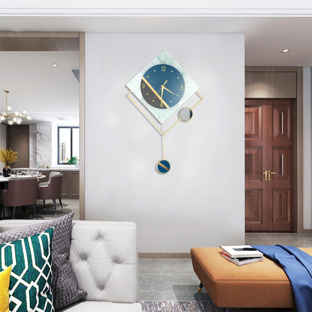 Moderne rautenförmige Wanduhr mit goldfarbenem Rahmen, blauem Zifferblatt und Pendel an weißer Wand.