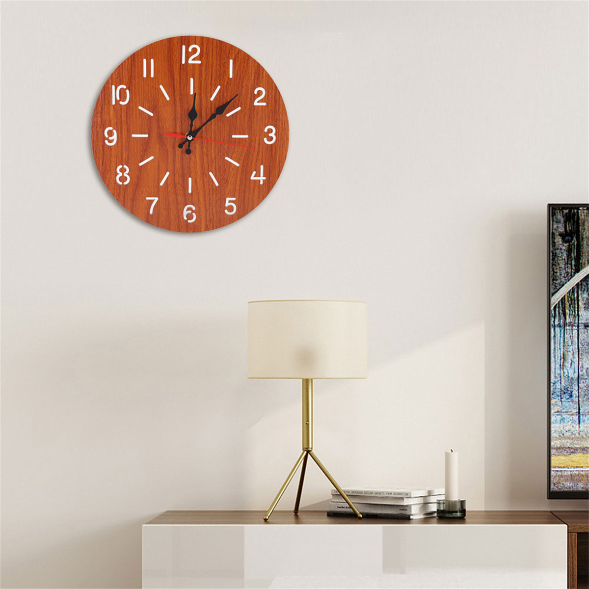 Holzuhr mit weißen Zahlen, an weißer Wand, mit Lampe und Tisch darunter.