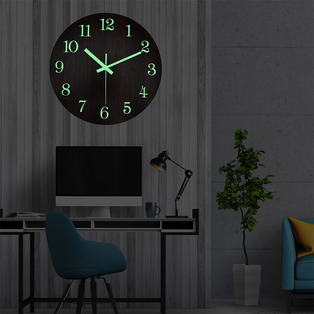 Holzwand mit Uhr, Schreibtisch, Monitor, Lampe und kleiner Pflanze.
