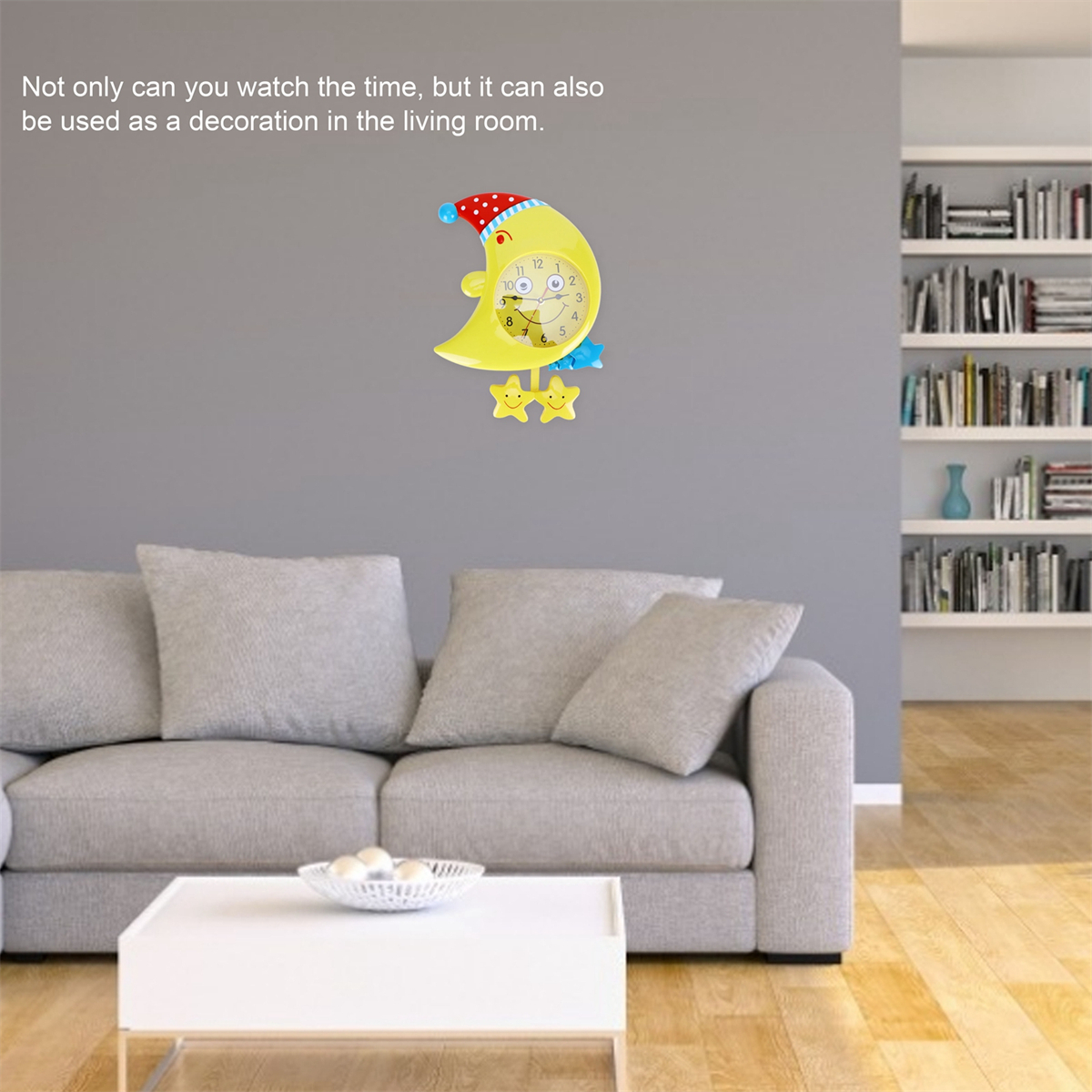 Gelbe Monduhr, zwei Sterne an grauer Wand. Graues Sofa und weißer Tisch im Hintergrund. Bücherregal.