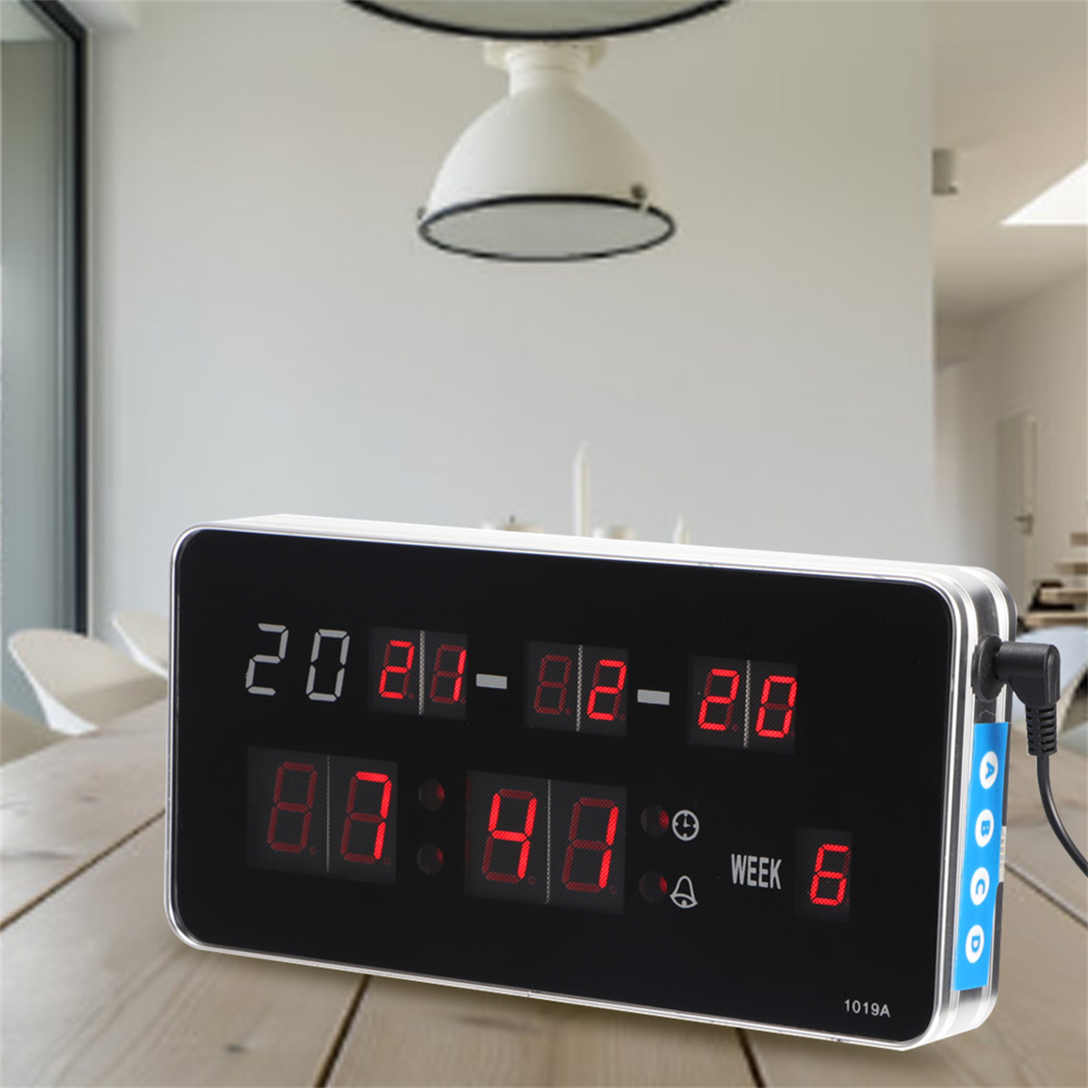 Digitale Uhr mit Datum und Uhrzeit, mit roten LEDs, auf einem Holztisch.