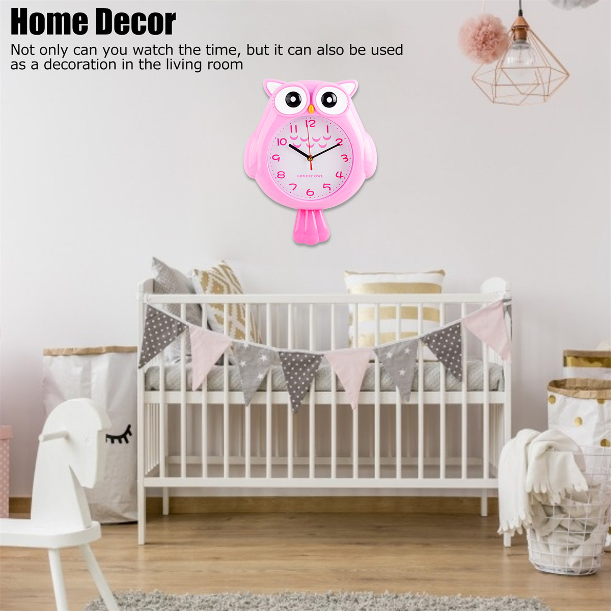 Rosa Eulen-Uhr an weißer Wand über einem Kinderbett mit Wimpelkette.