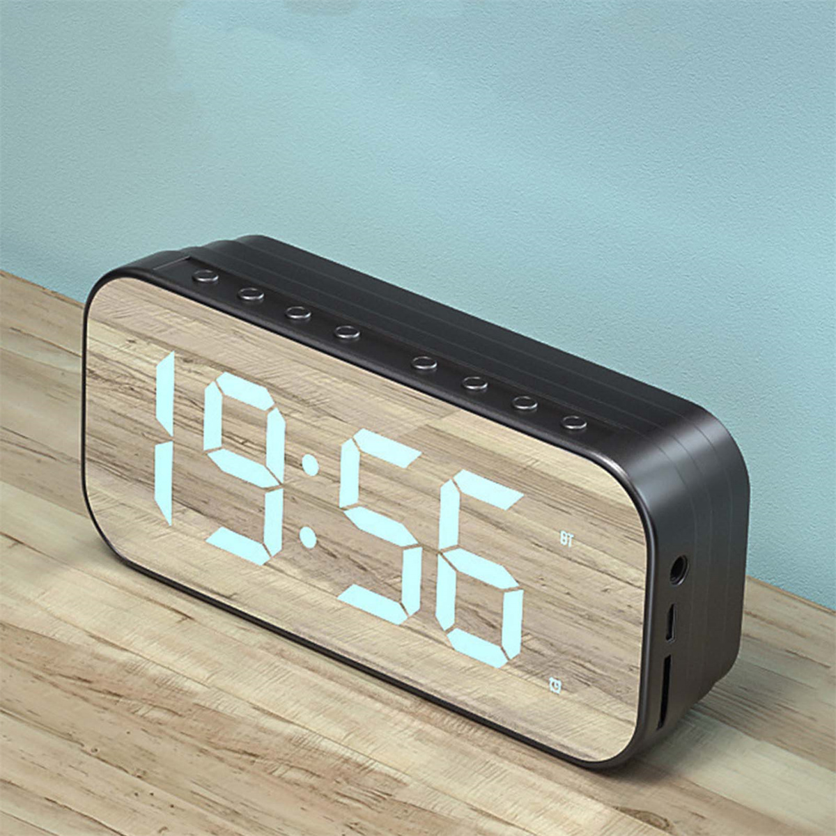 Eine schwarze Digitaluhr mit Holzfront zeigt 19:56 und ein BT-Symbol.