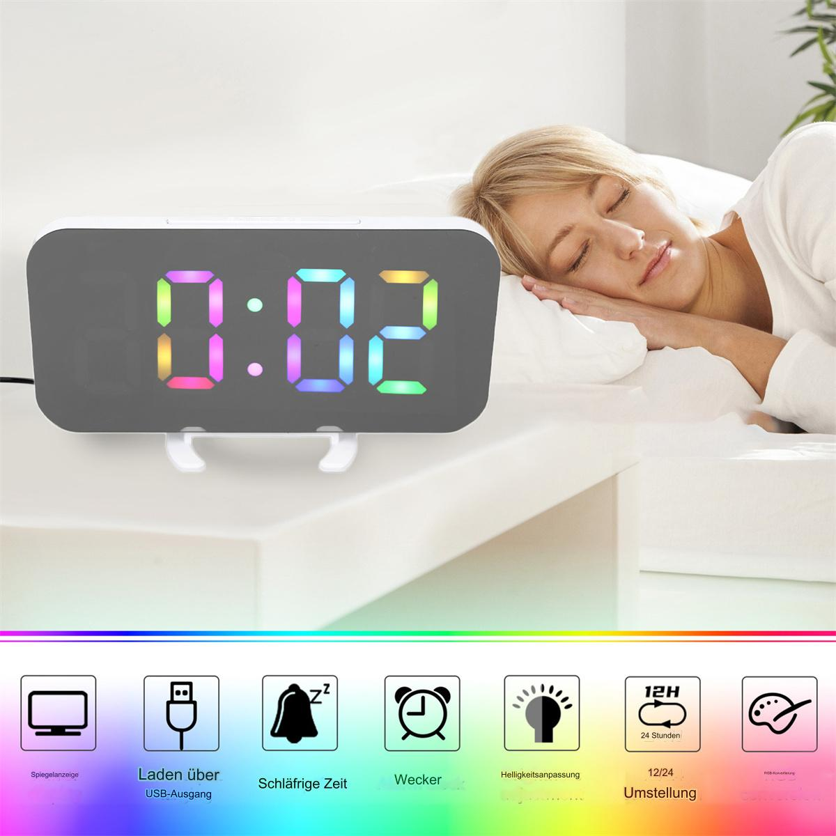 Digitaler Wecker mit Regenbogenanzeige, zeigt die Zeit, auf einem weißen Nachttisch.