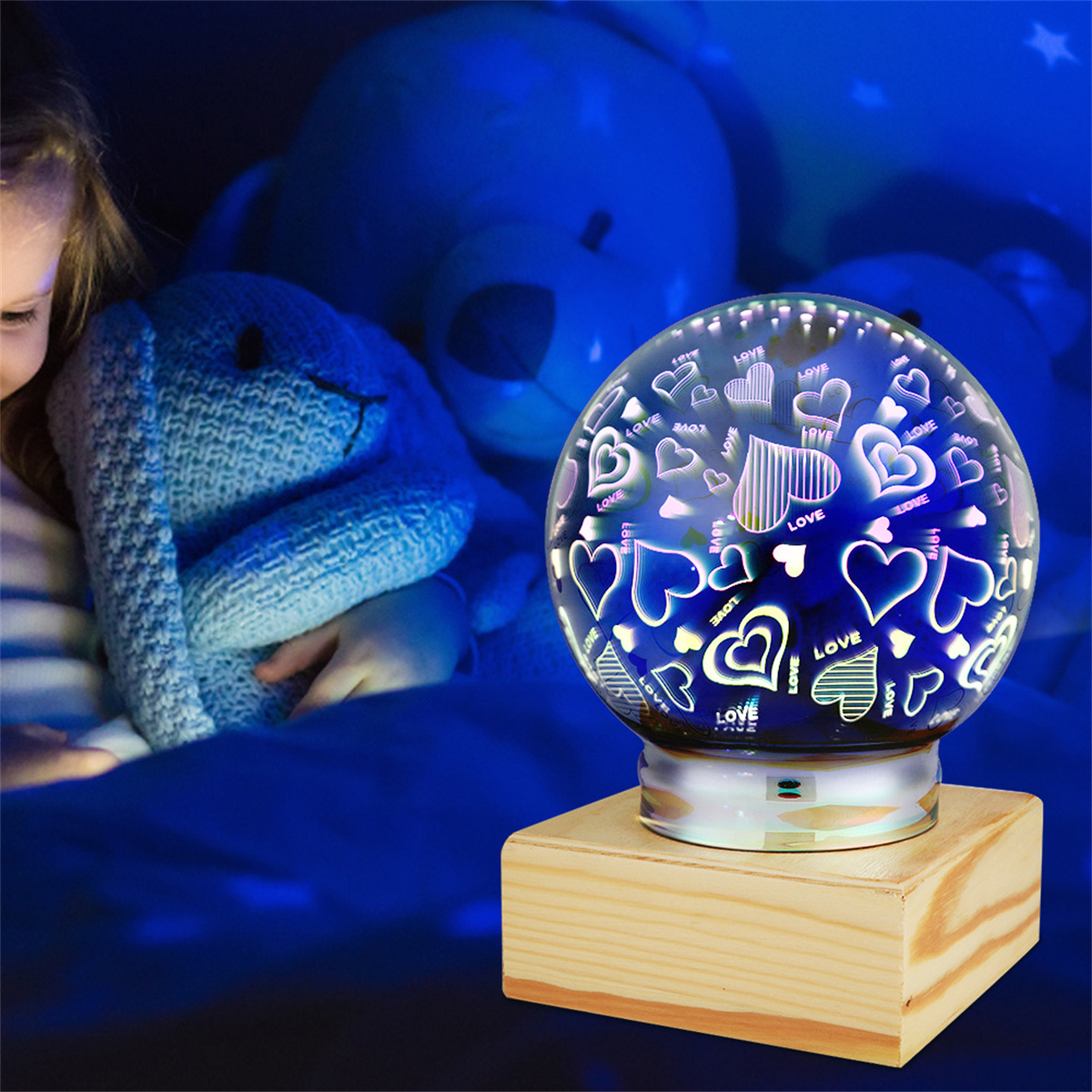 Eine mit Herzen dekorierte Schneekugel auf einem Holzsockel, in einem Kinderzimmer mit einem blauen Stofftier.