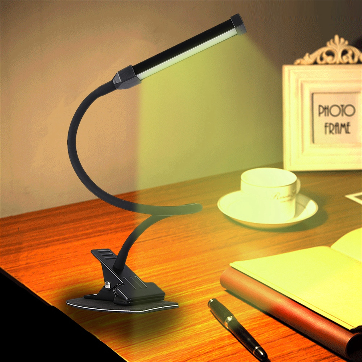 Eine schwarze Schreibtischlampe mit flexiblem Arm, die Licht auf einen Schreibtisch mit Stift und Papier wirft.