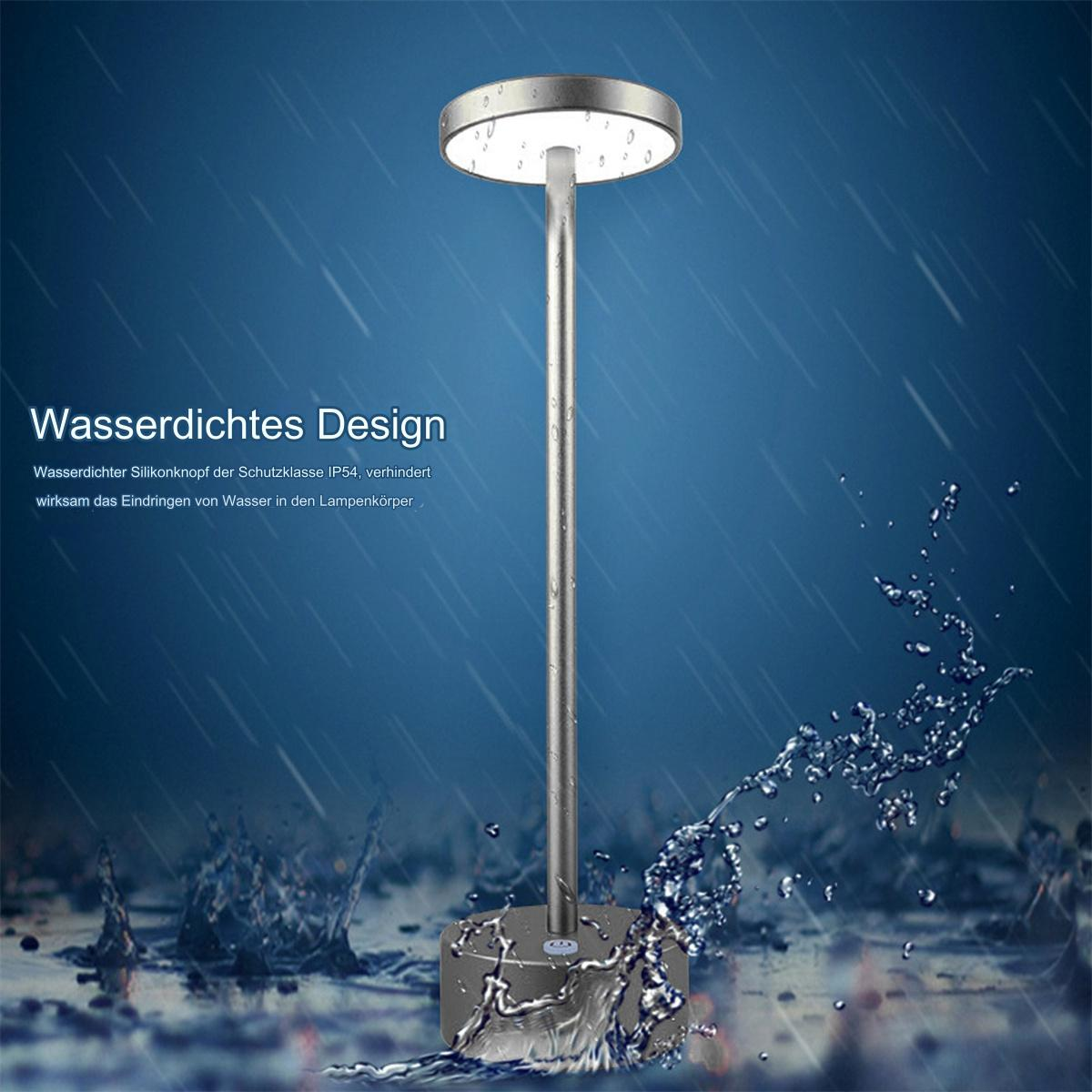 Silberne Lampe mit langem Stiel, Wasser spritzt darum herum, auf blauem Hintergrund.