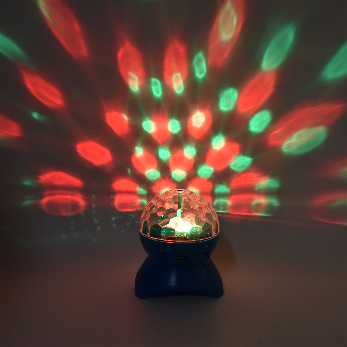Diskokugel mit rotem und grünem Licht. Das Licht wirft Muster auf eine Oberfläche.