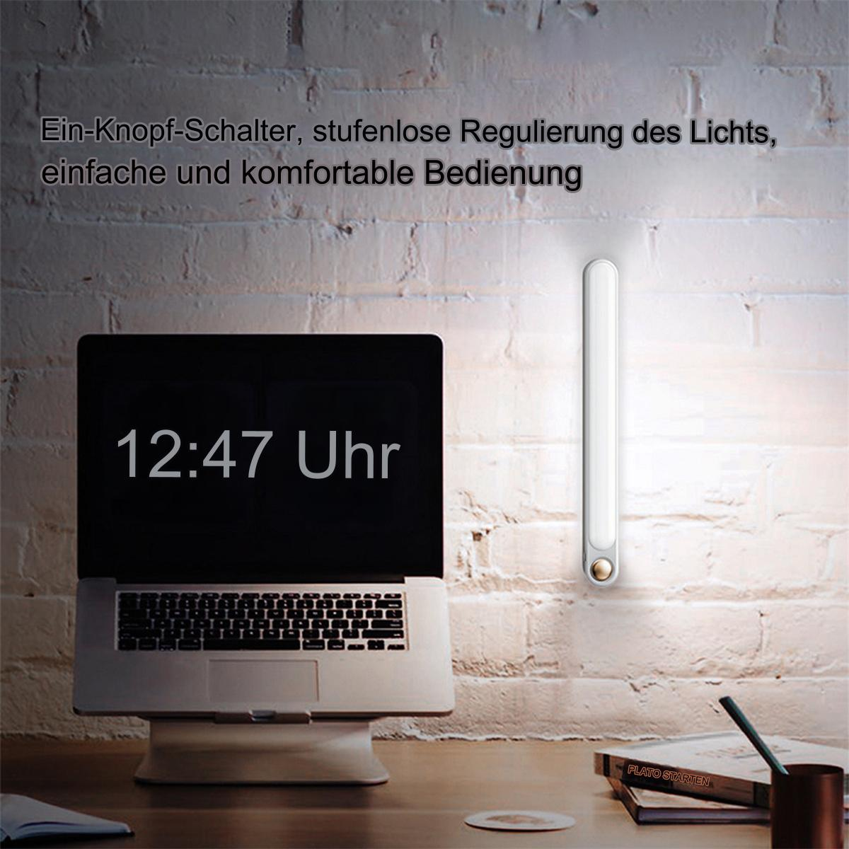 Laptop mit beleuchtetem Bildschirm und einem vertikalen, langen Licht an der Wand. Text an der Wand.